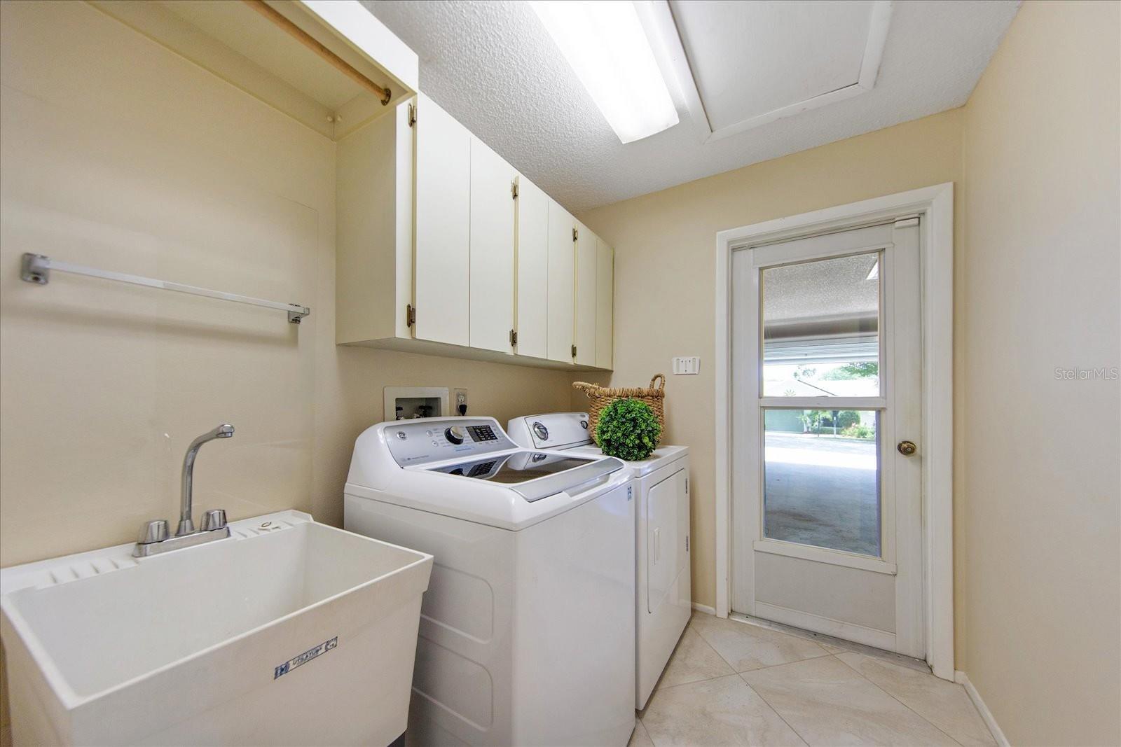 Laundry room with utility sink & extra cabinets opens to hall & garage~