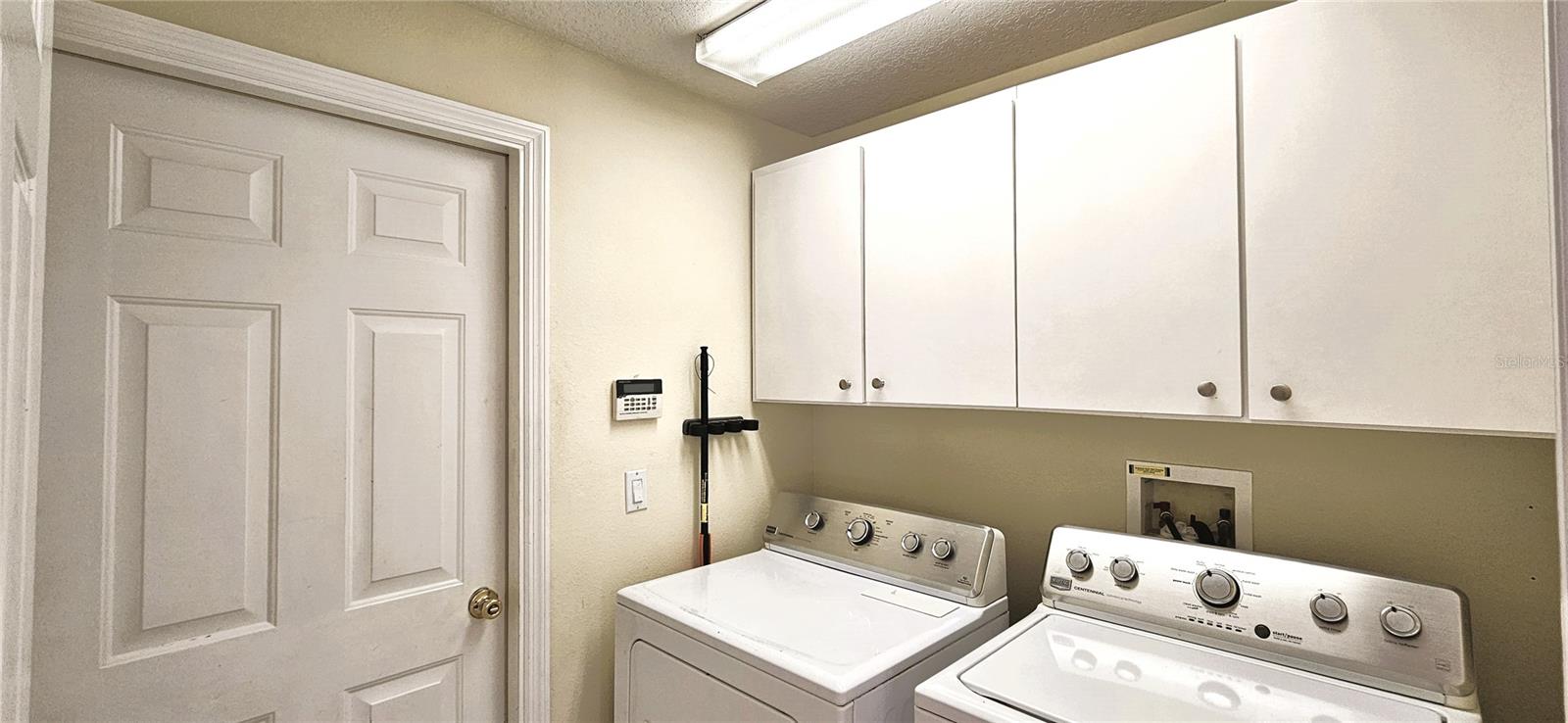 Utility room includes cabinets and lighting