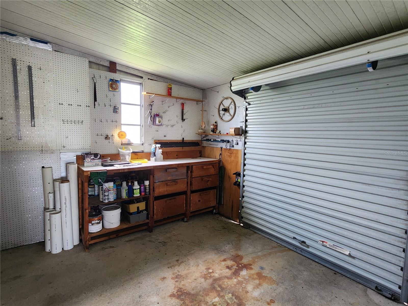 Attached golfcart parking/workshop with roll up door.