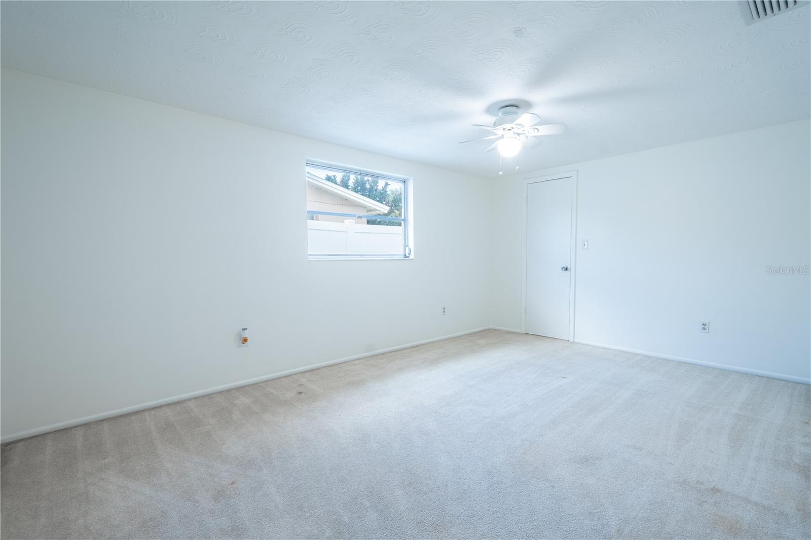 Bedroom 2 features neutral tone carpet, a ceiling fan with light kit, and a built-in closet.