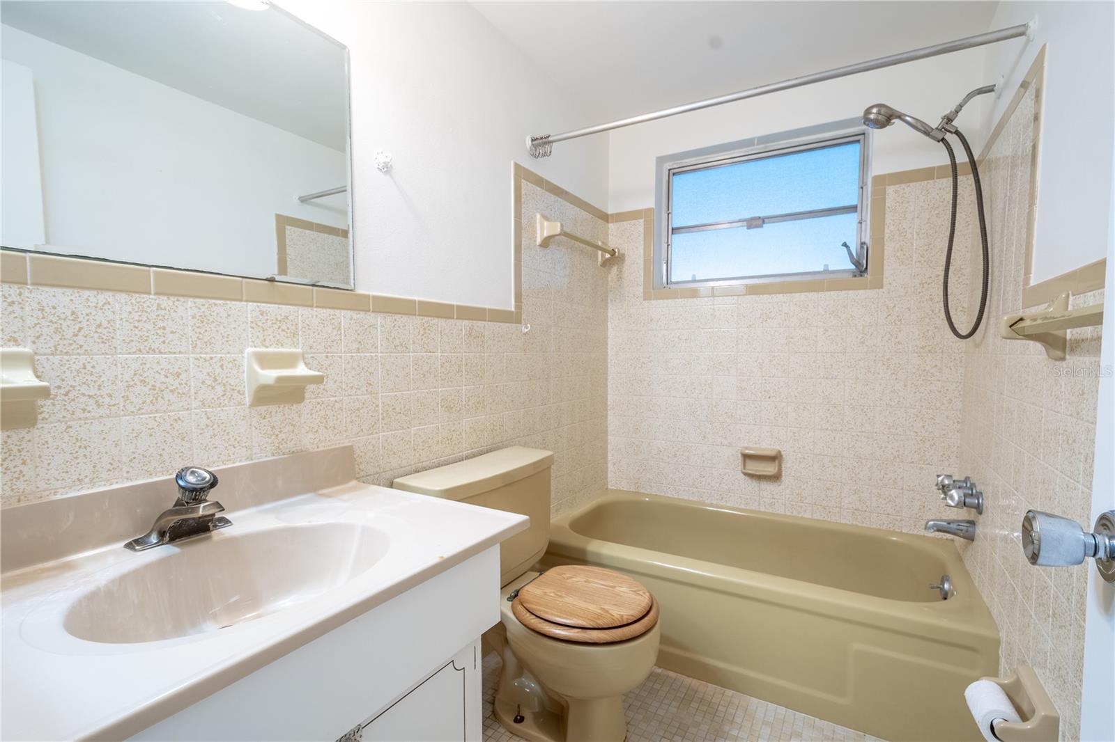 Bathroom 2 features a tub with shower and a mirrored vanity with storage.