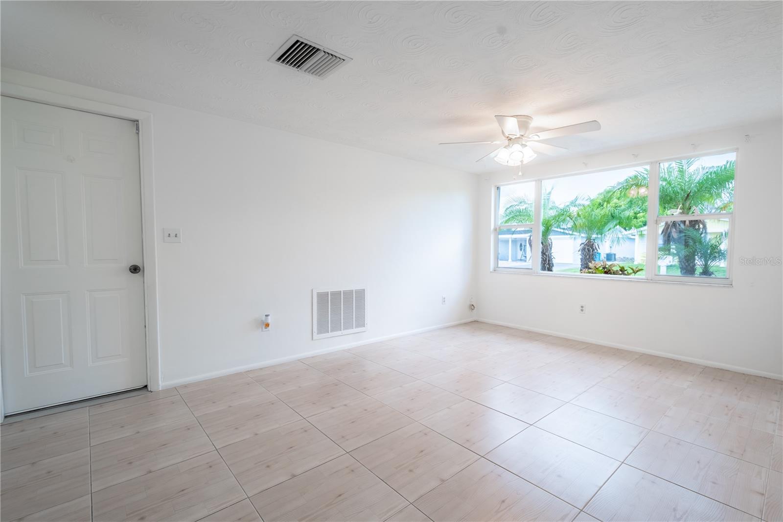 The family room features large ceramic tile flooring in a neutral tone.
