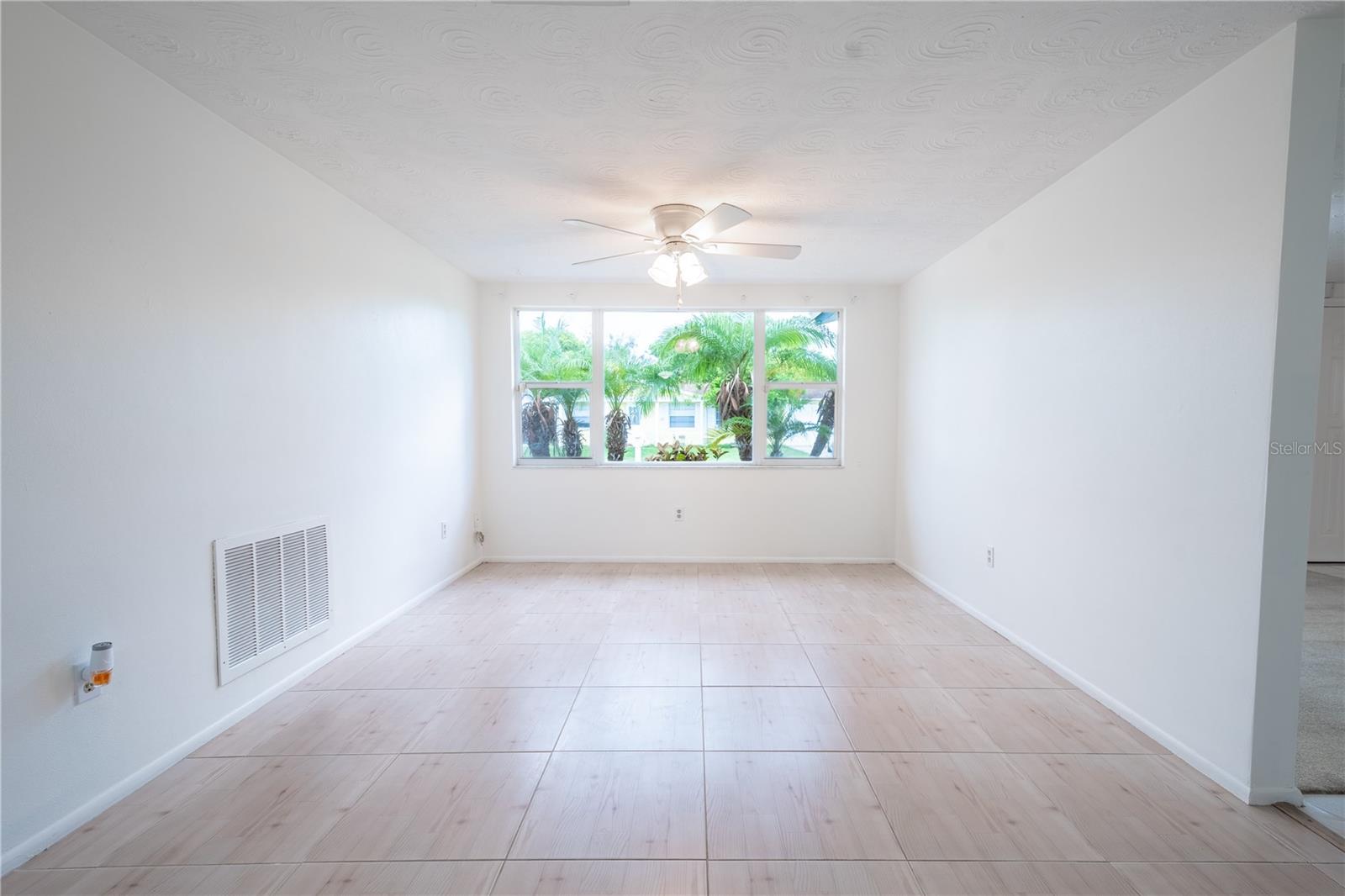 A large picture window in the family rooms frames the tropical landscape.