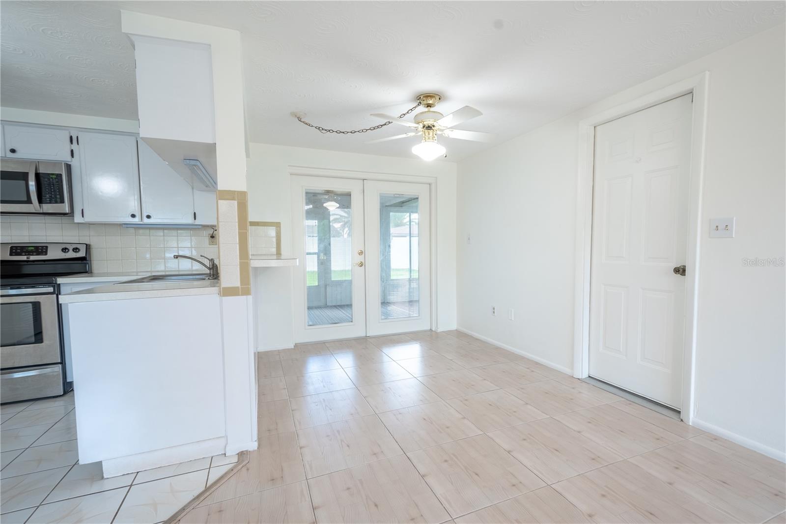 The dinette features ceramic tile flooring, a ceiling fan and French doors that open to the Florida room.