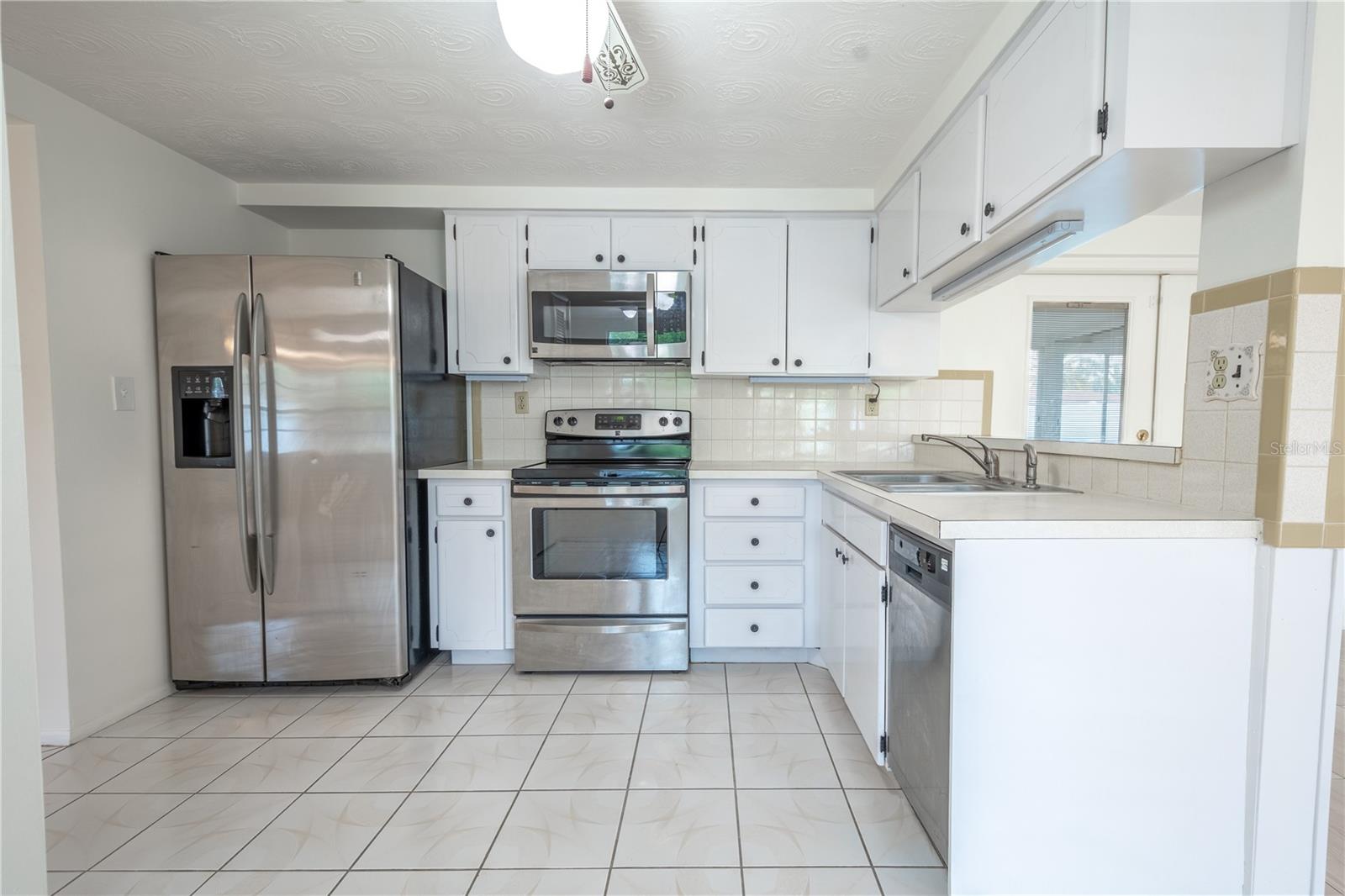 The kitchen features a suite of stainless steel appliances including a French door refrigerator with water dispenser, Range, Microwave and Dishwasher.