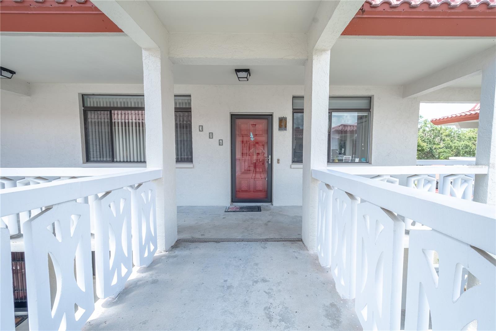 A covered entryway with a welcoming red front door. Red doors have traditionally represented safe havens.