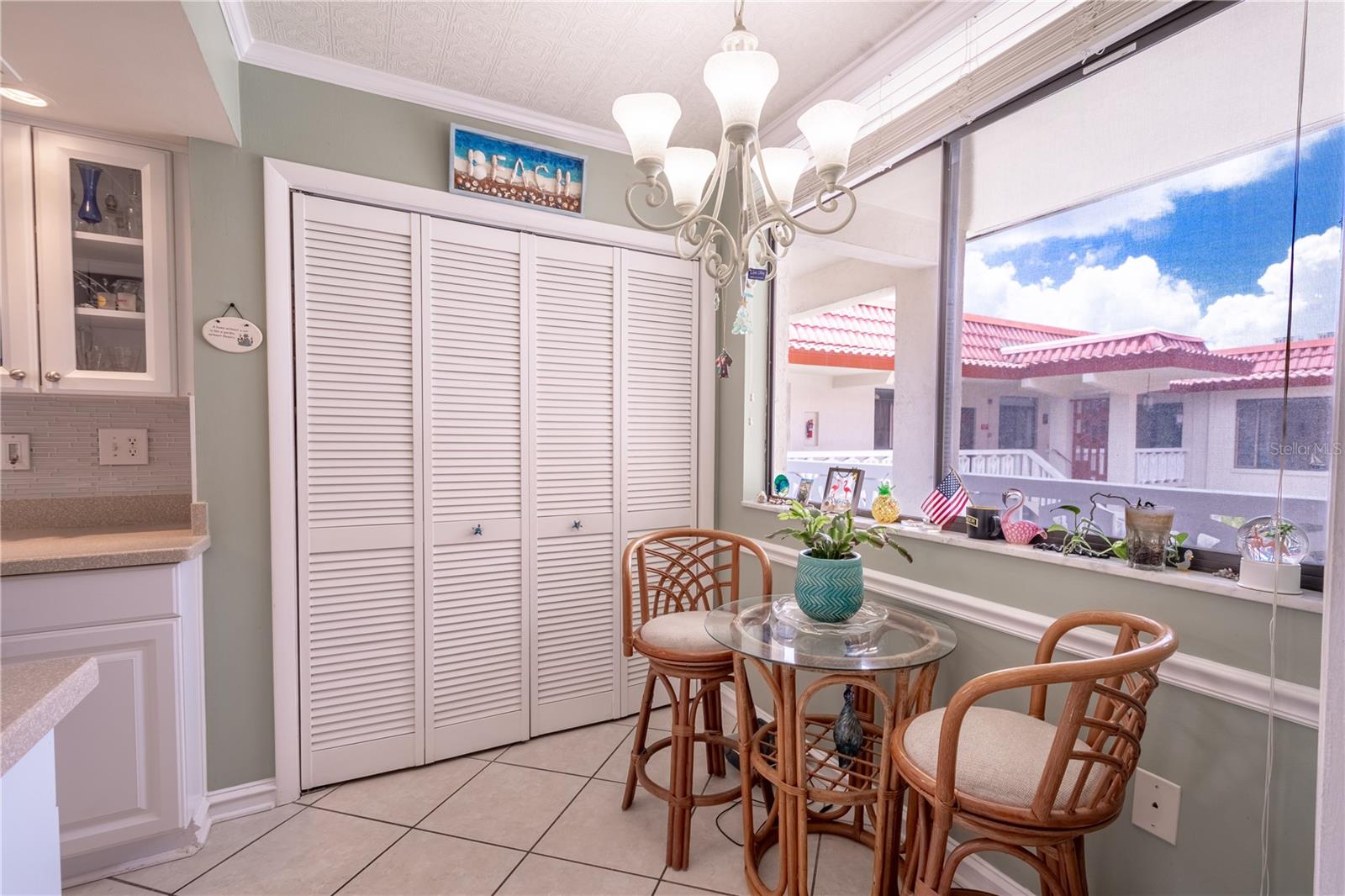 The breakfast nook features crown molding and neutral tone ceramic tile flooring.