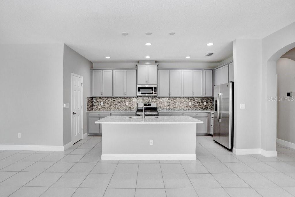 Kitchen with 42" cabinets, quarter countertops, stainless steel appliances, and back splash