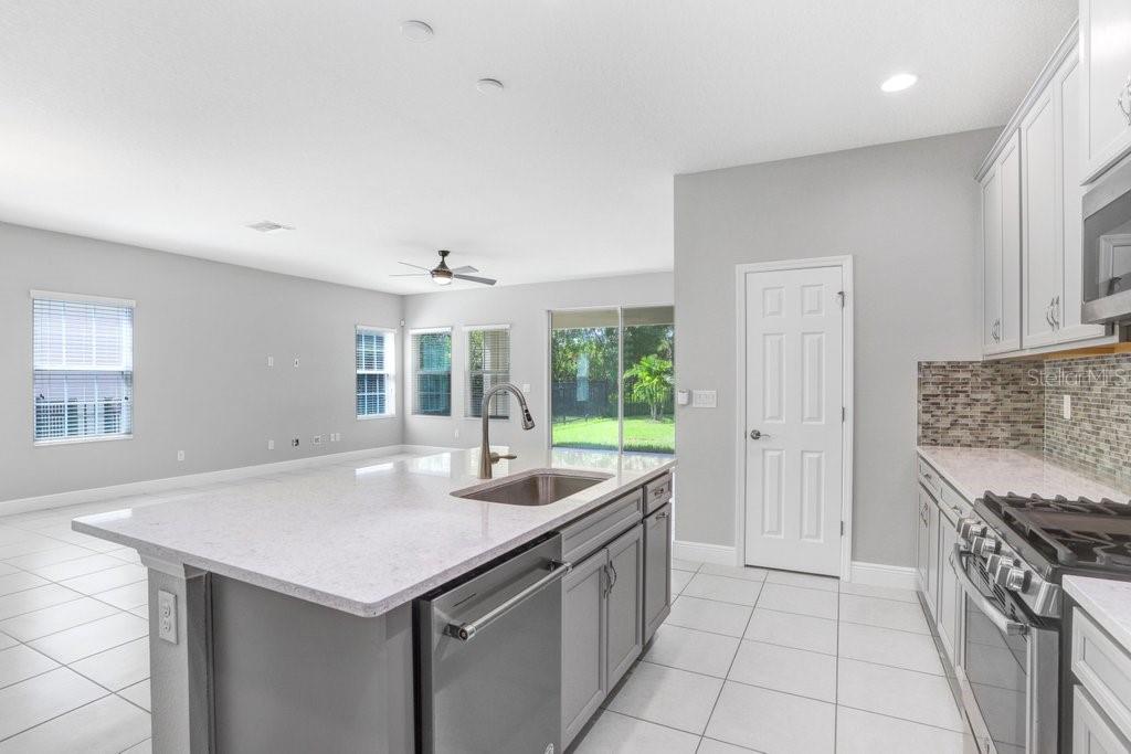 Kitchen with 42" cabinets, quarter countertops, stainless steel appliances, and back splash