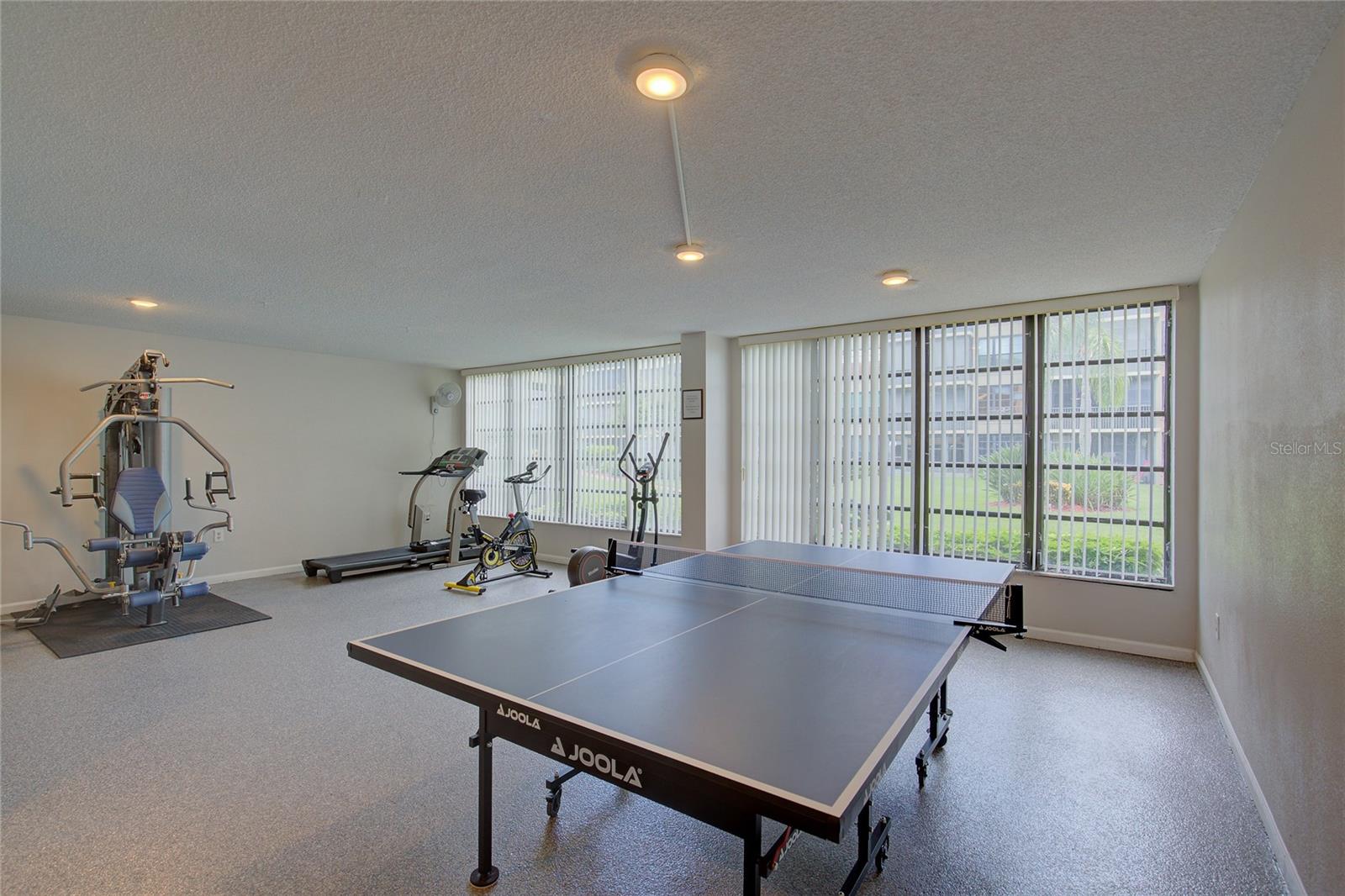 Exercise equipment room with pool table.