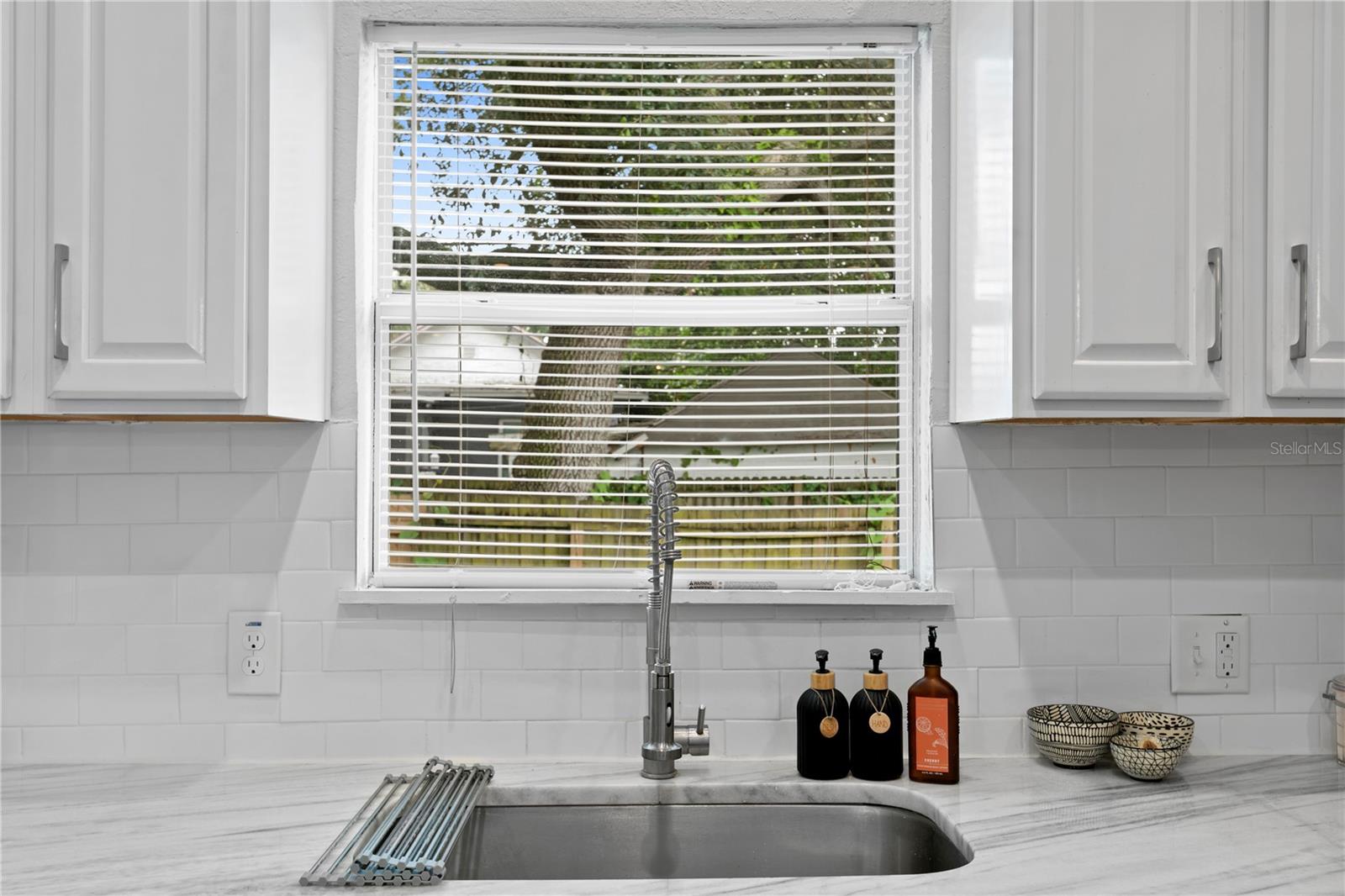 Kitchen window looking out to backyard