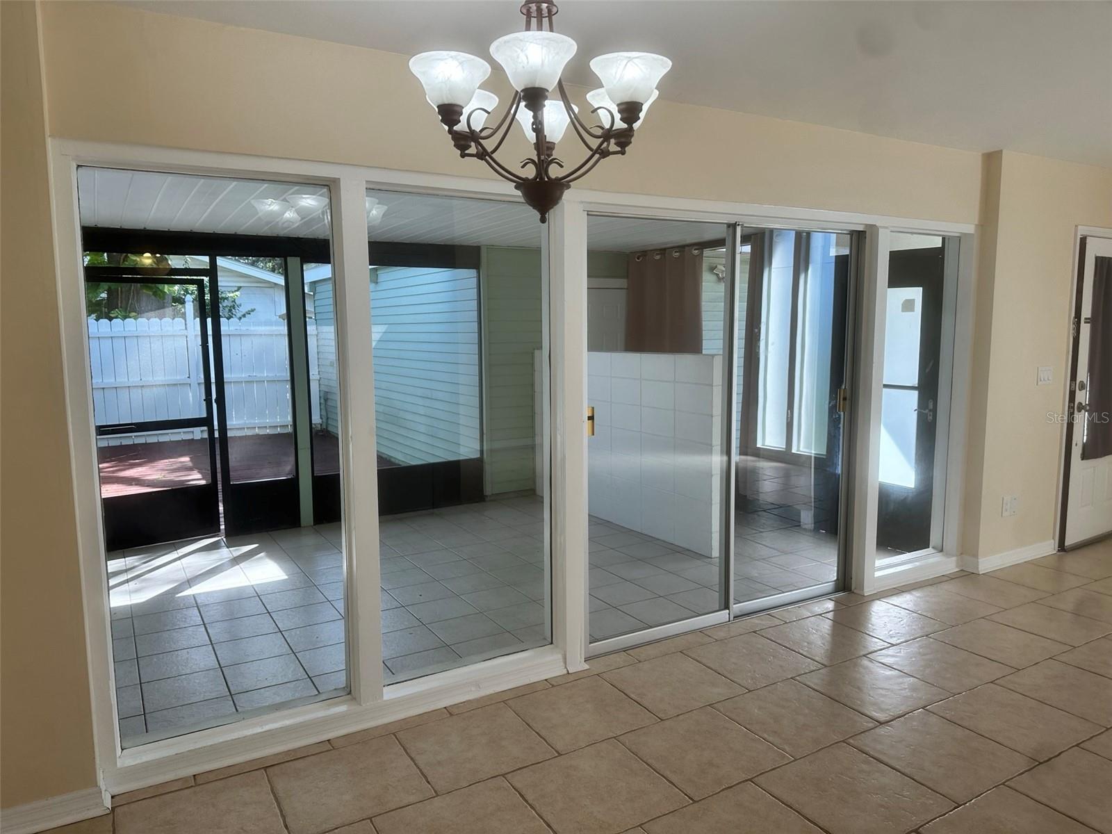 Dining area facing screened in patio; deck ahead and garage door to the right