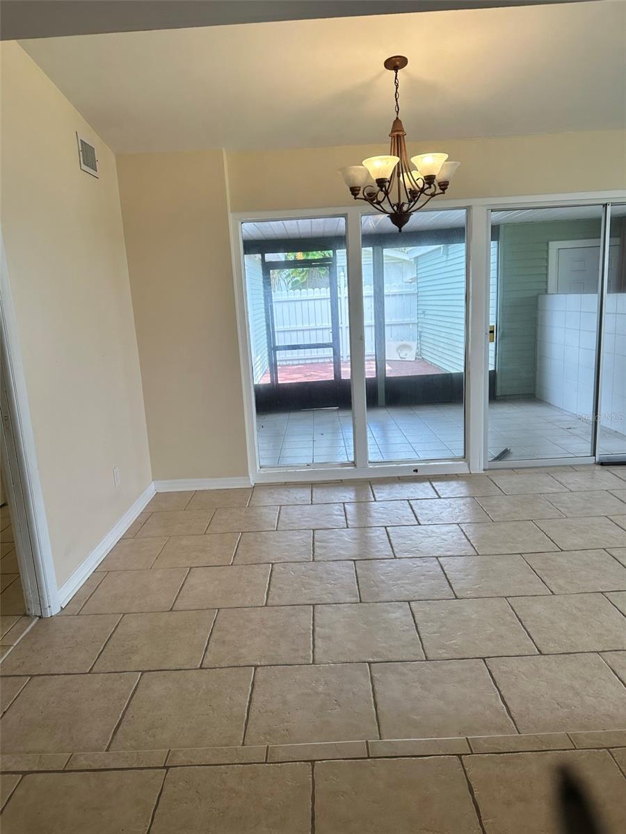 Dining room area facing screened in Patio and Deck ahead of that. Garage door to the right