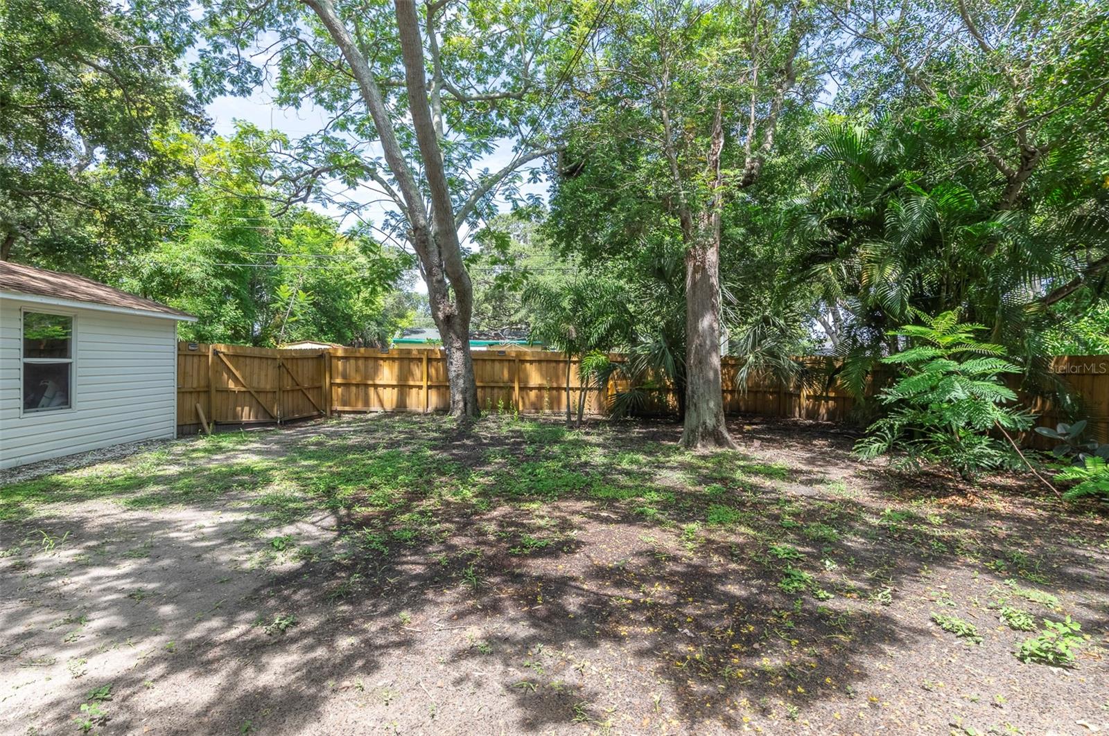 large yard, detached garage, mature trees, newer wood fence