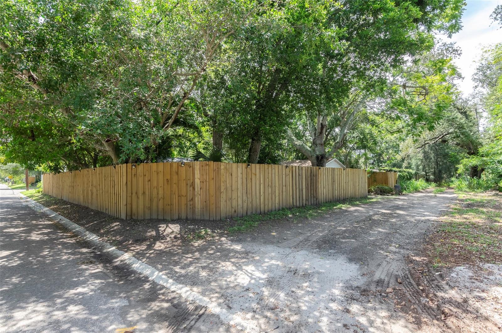 view from the street and alley, beautiful trees and wood fence.