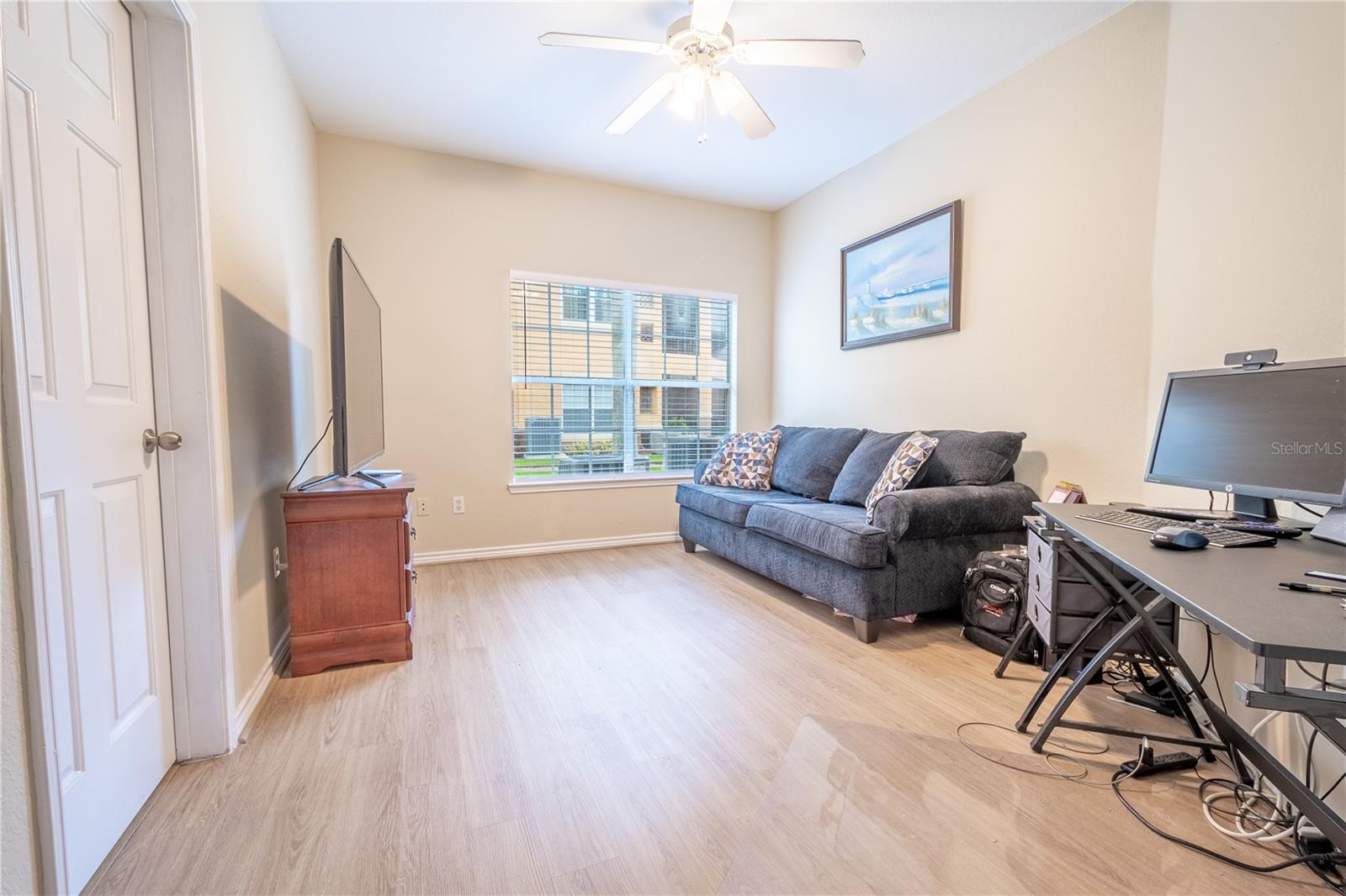 The primary bedroom features luxury vinyl flooring, a neutral color palette, a ceiling fan with light kit and an ensuite bath.