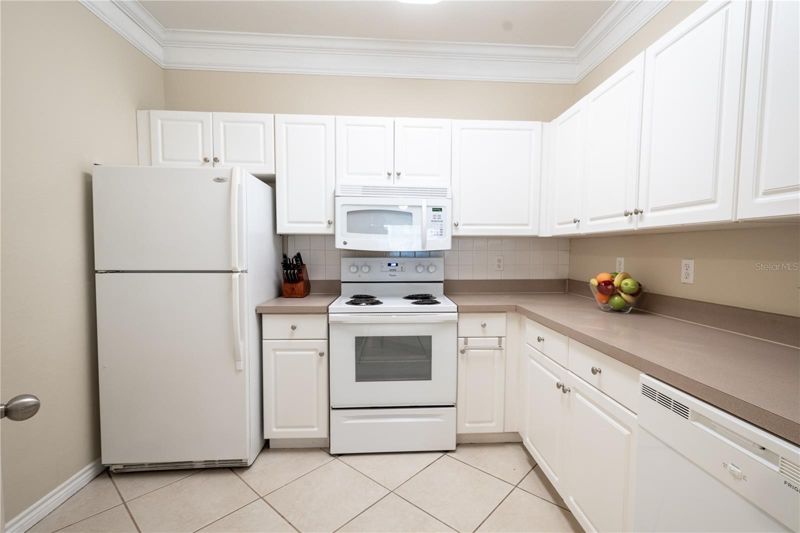 The kitchen features a full suite of appliances included a range, a microwave, refrigerator and dishwasher.