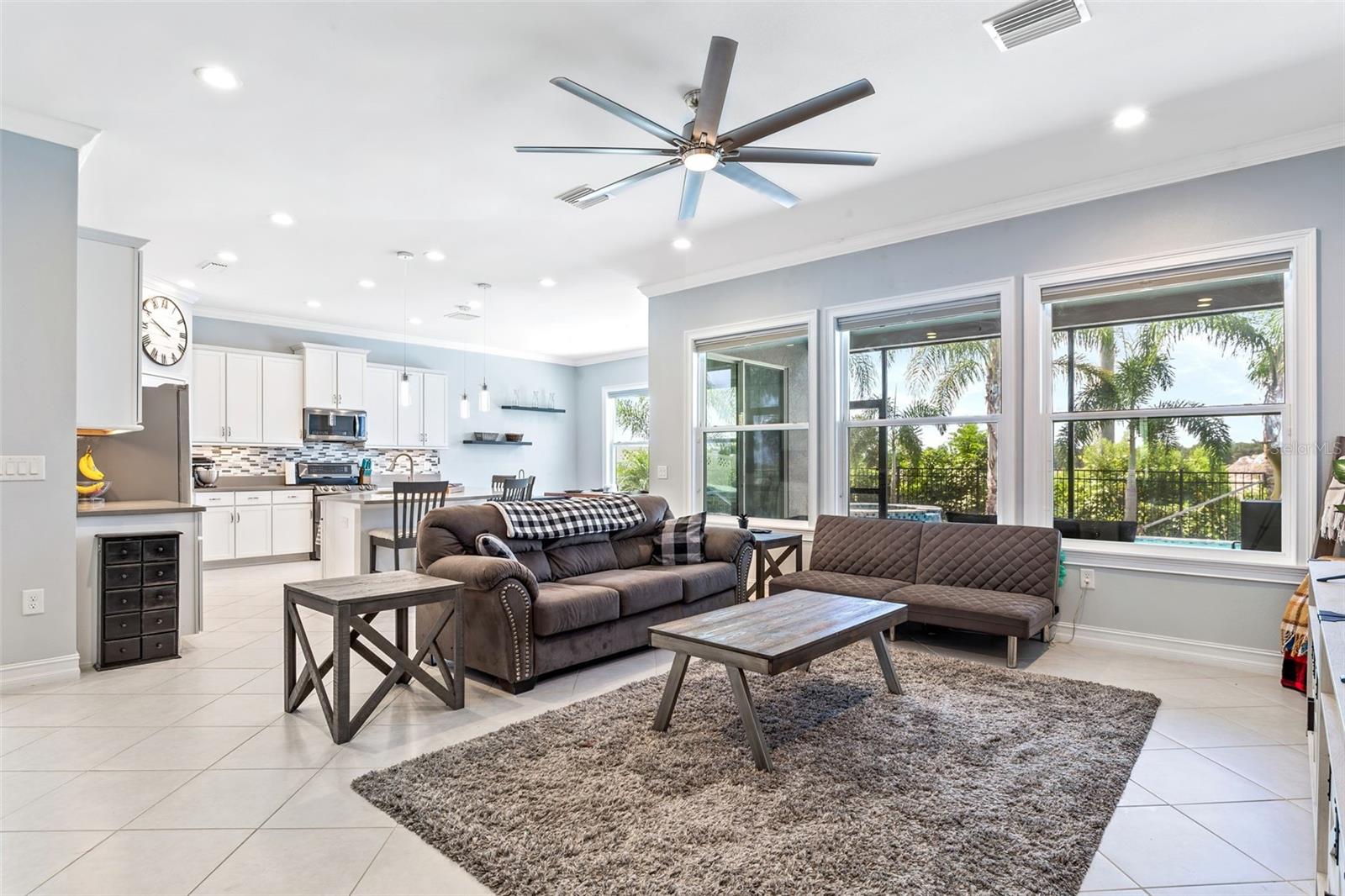 Your spacious floorplan convenes at the hearth of the home in this open living space with access to the kitchen and view of the pool.