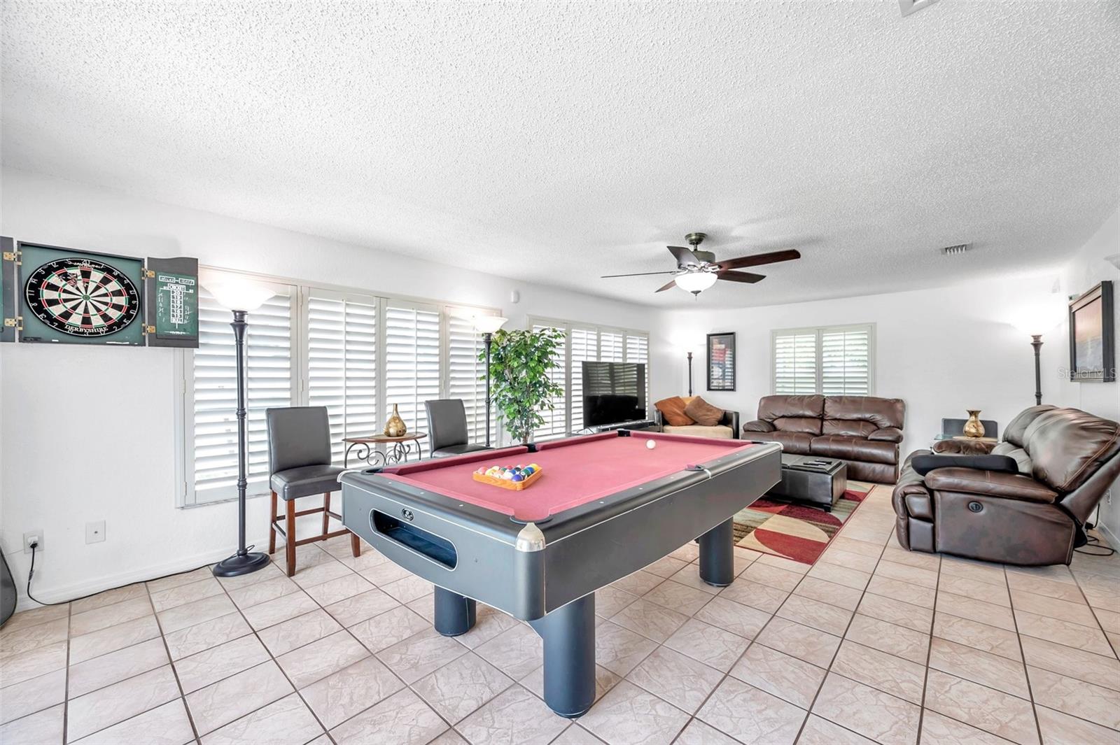 The oversized Florida room allows for additional entertaining. Situated between the kitchen and the outdoor patio, this is the perfect place to gather and enjoy friends and family!