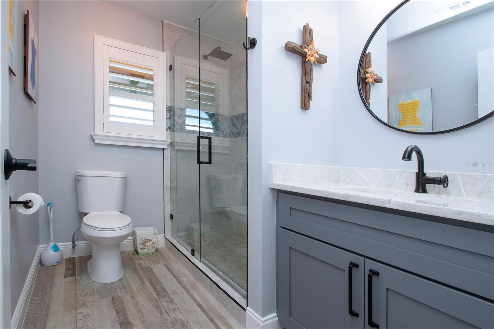 Remodeled Bathroom With Walk-In Tiled Shower and Glass Doors