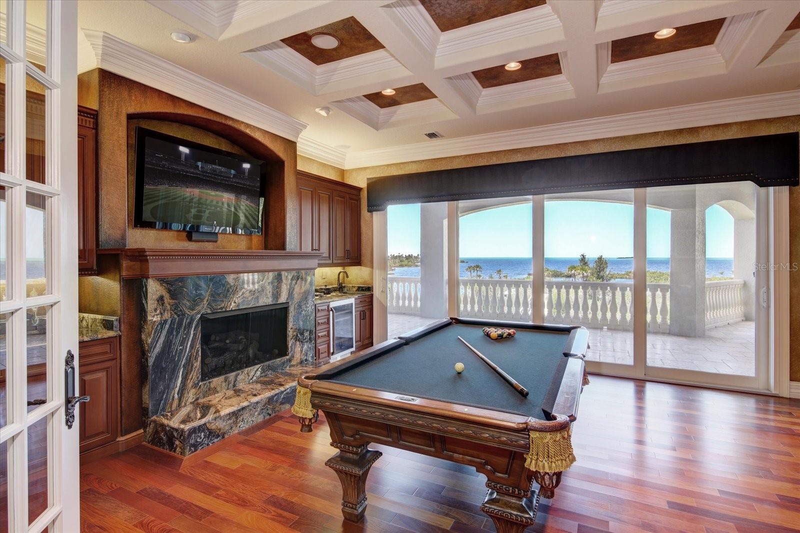 The billiard room with  coffered ceiling, faux paint on walls & ceiling with a 4-panel sliding glass door leading out to the terrace with perfect west facing views of the Gulf of Mexico.