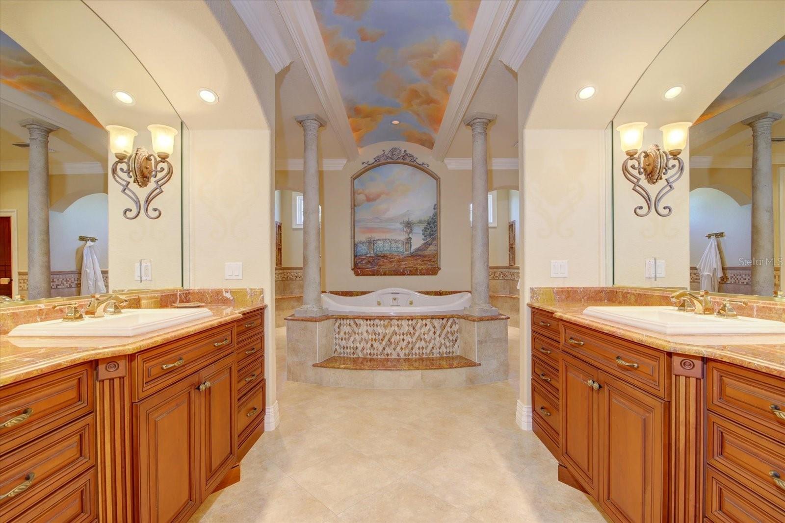 The luxuriant en suite bath with double sinks, built in solid cherry cabinetry, granite countertops, & recessed lighting