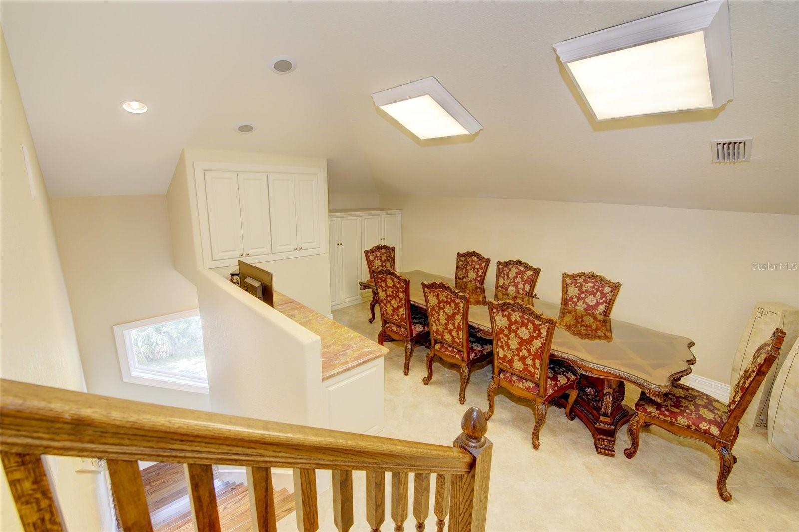 Gift-wrapping room with vaulted ceiling, built in cabinets, granite desk, wood drawers and cupboards