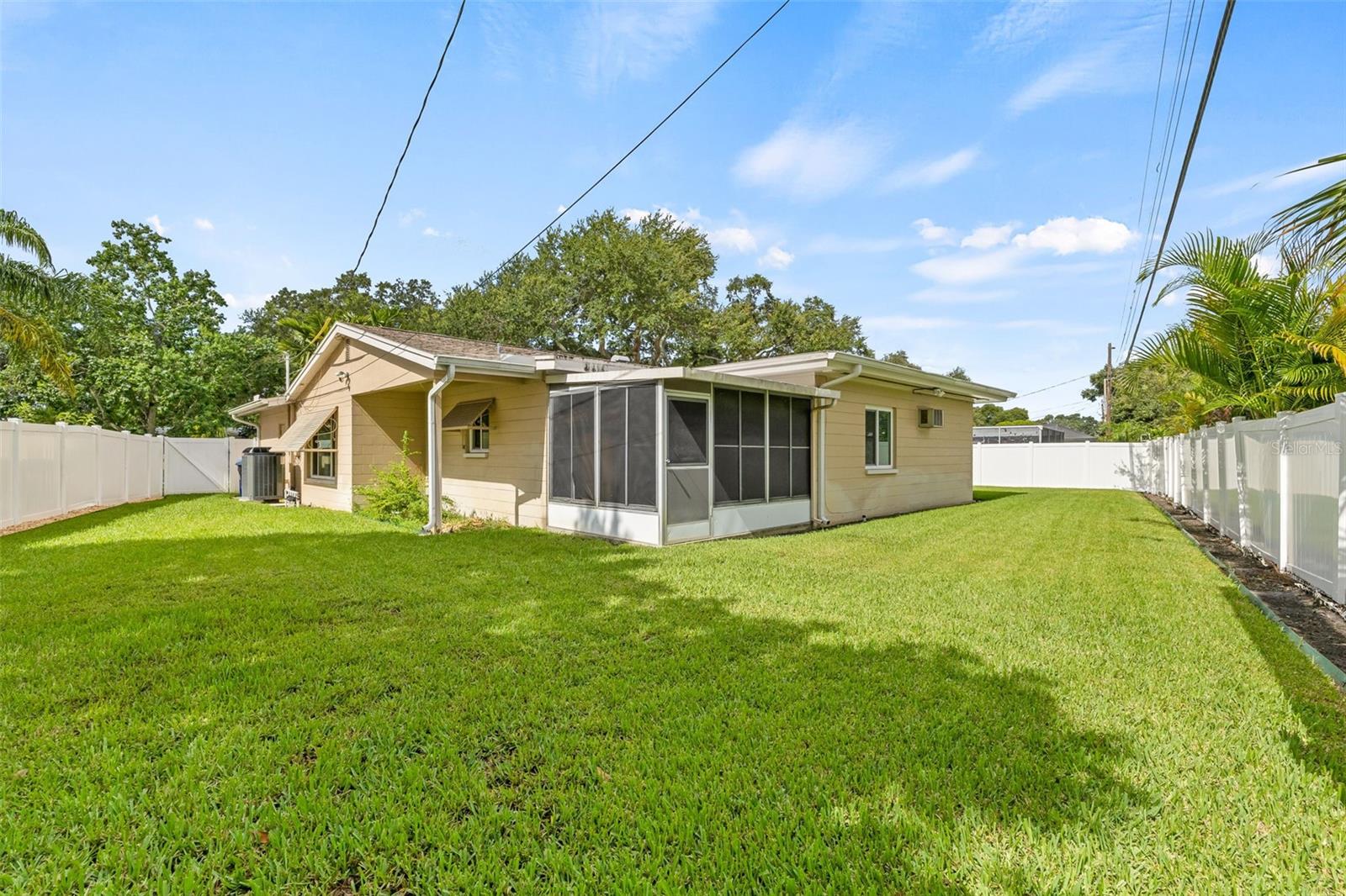 Spacious backyard with fully vinyl fence and a screened in porch.