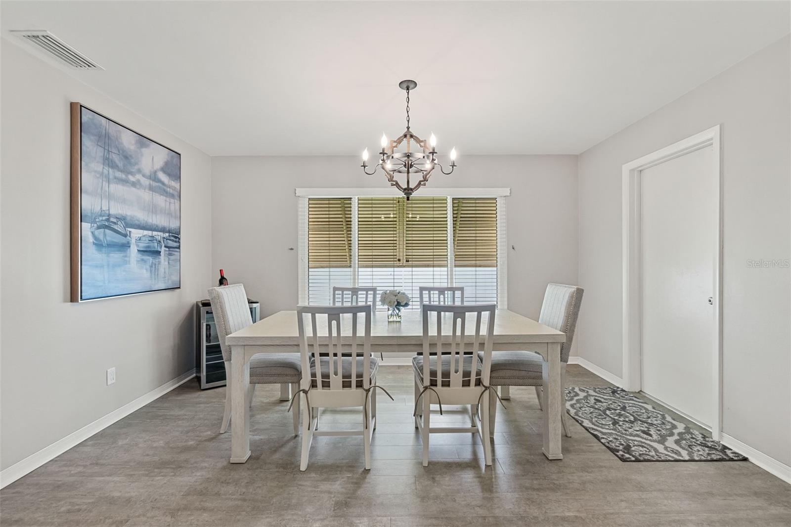 Large Dining Room located off the kitchen. The door to the right is garage access. Window has an awning.