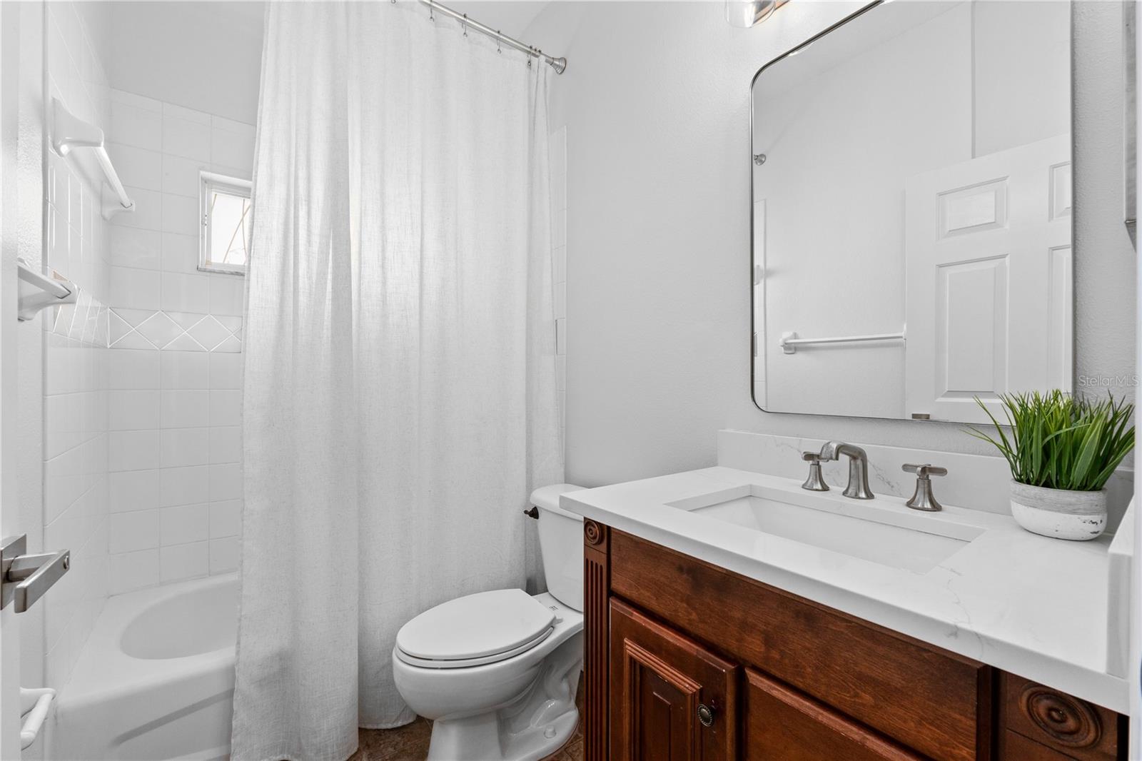 Bathroom 2 with Quartz countertop, updated lighting & mirror