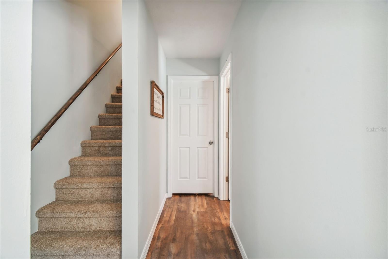 Hallway to Full Bath and Laundry with Stairs leading to Bonus Room