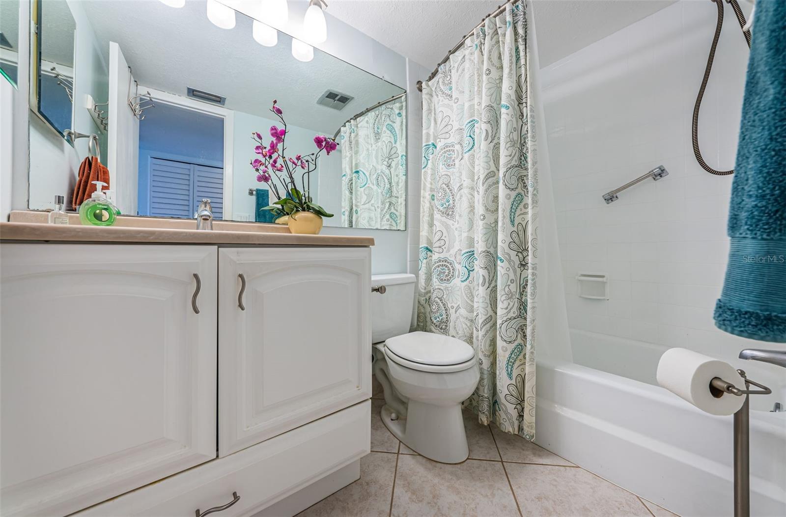 Bathroom with shower and new vanity, toilet and lighting.