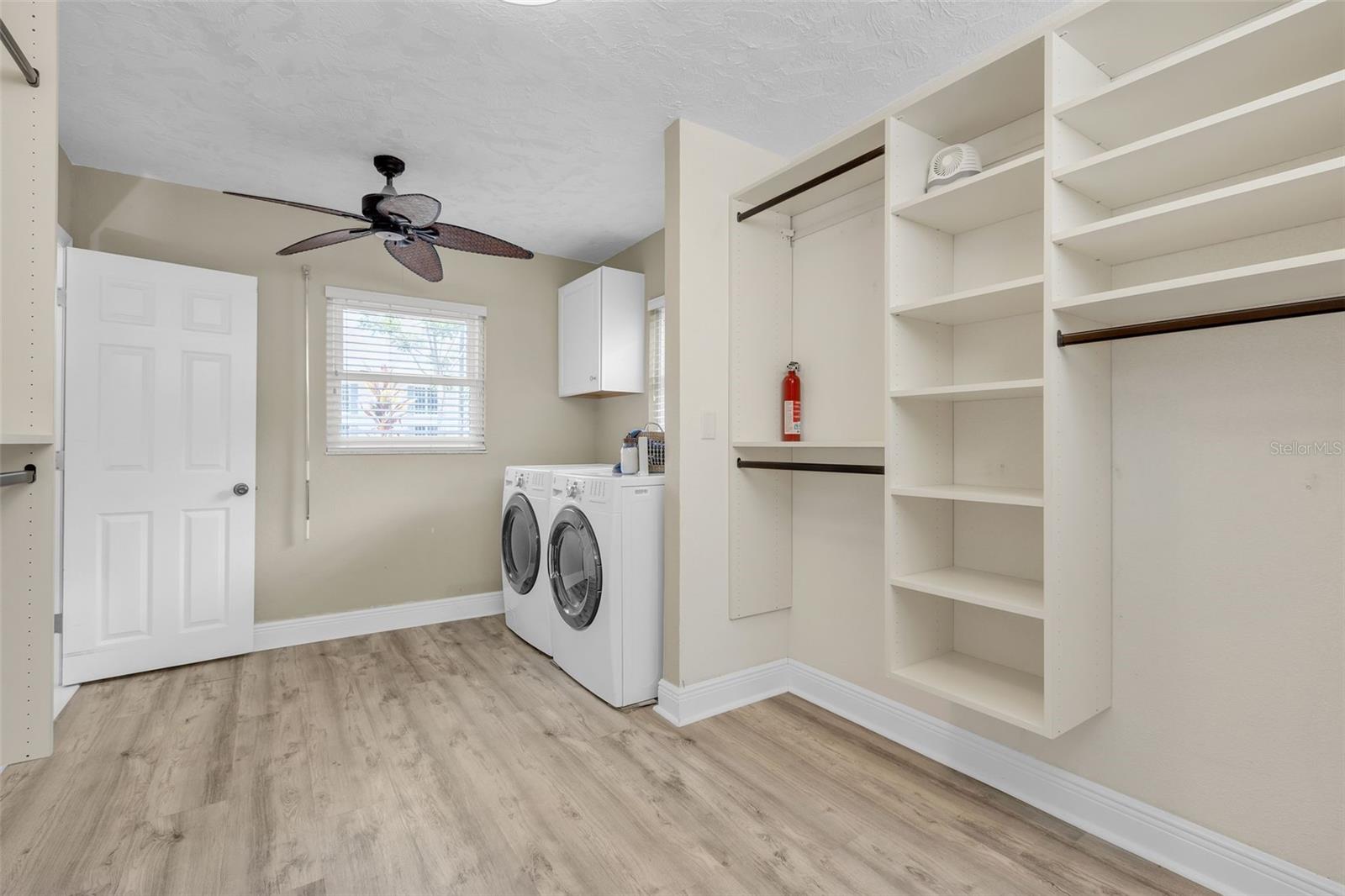 washer and dryer in primary walk in closet for convenience