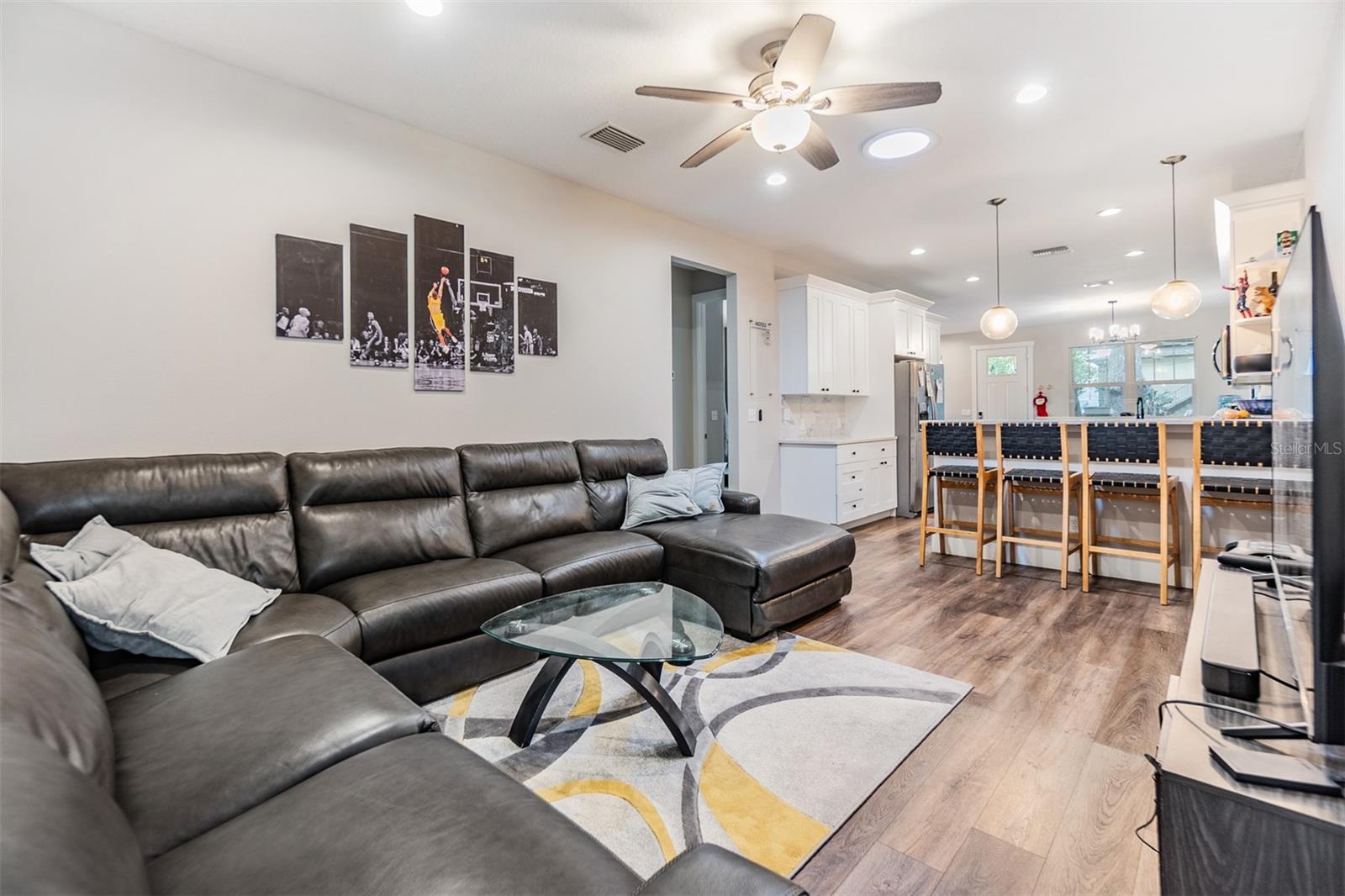 Family room, just off of the kitchen, ceiling fan, 5 inch baseboards and high ceilings.