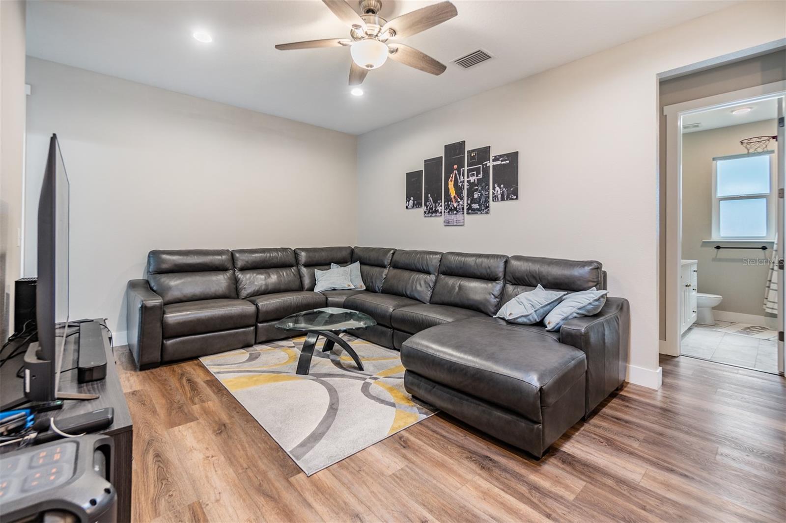 Family room, just off of the kitchen, ceiling fan, 5 inch baseboards and high ceilings.