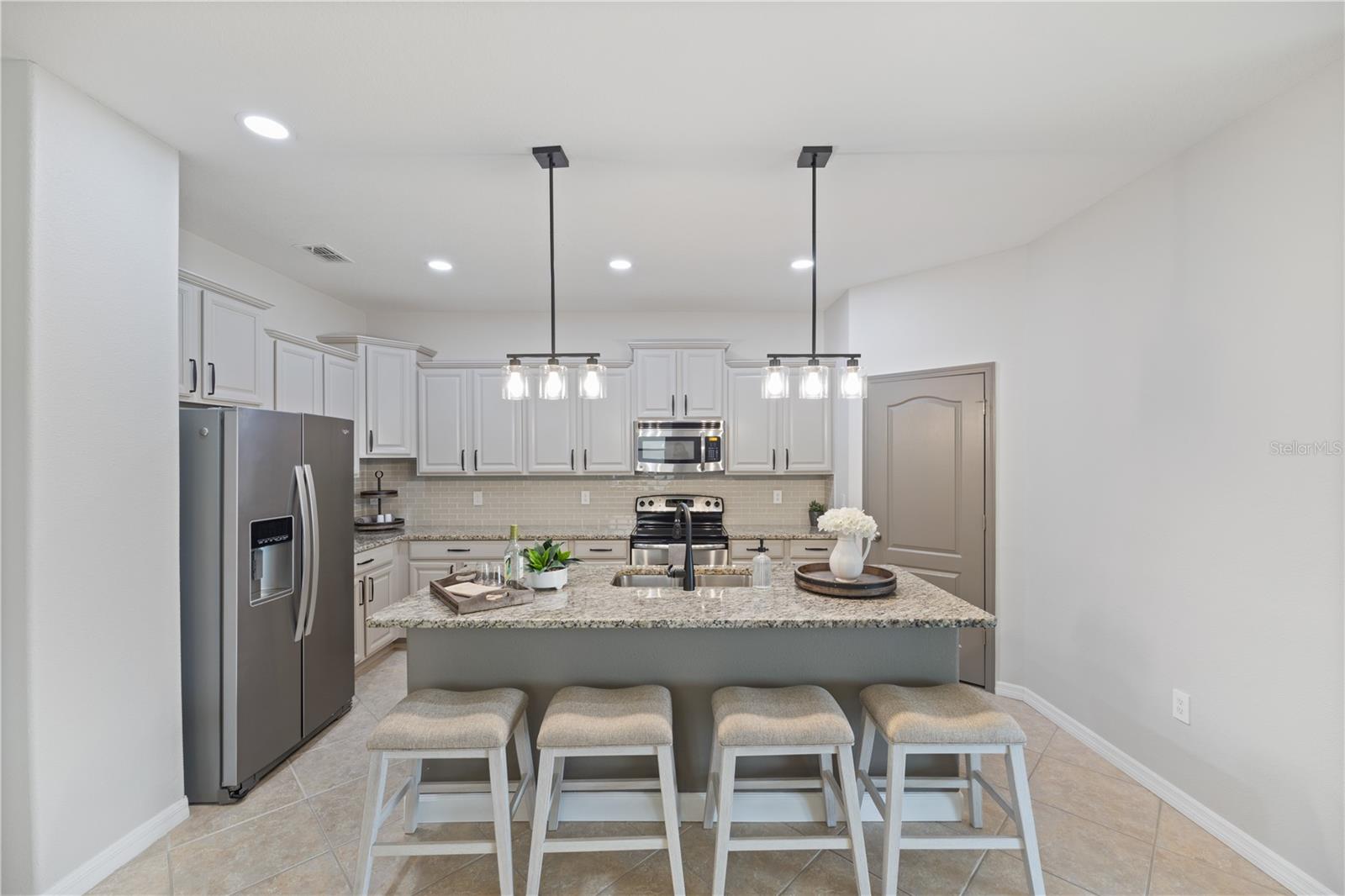 Light upper cabinets and darker lower cabinets with pantry door painted to match lower cabinets