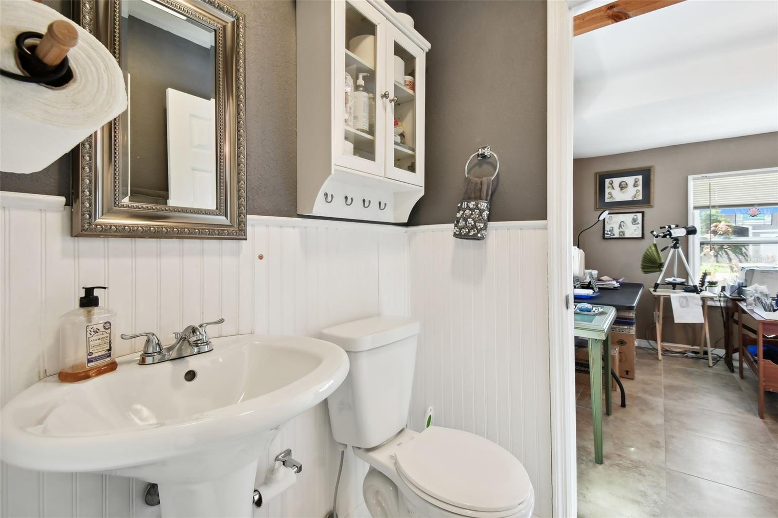 1/2 bath with wainscoting commode and pedestal sink. Adorable