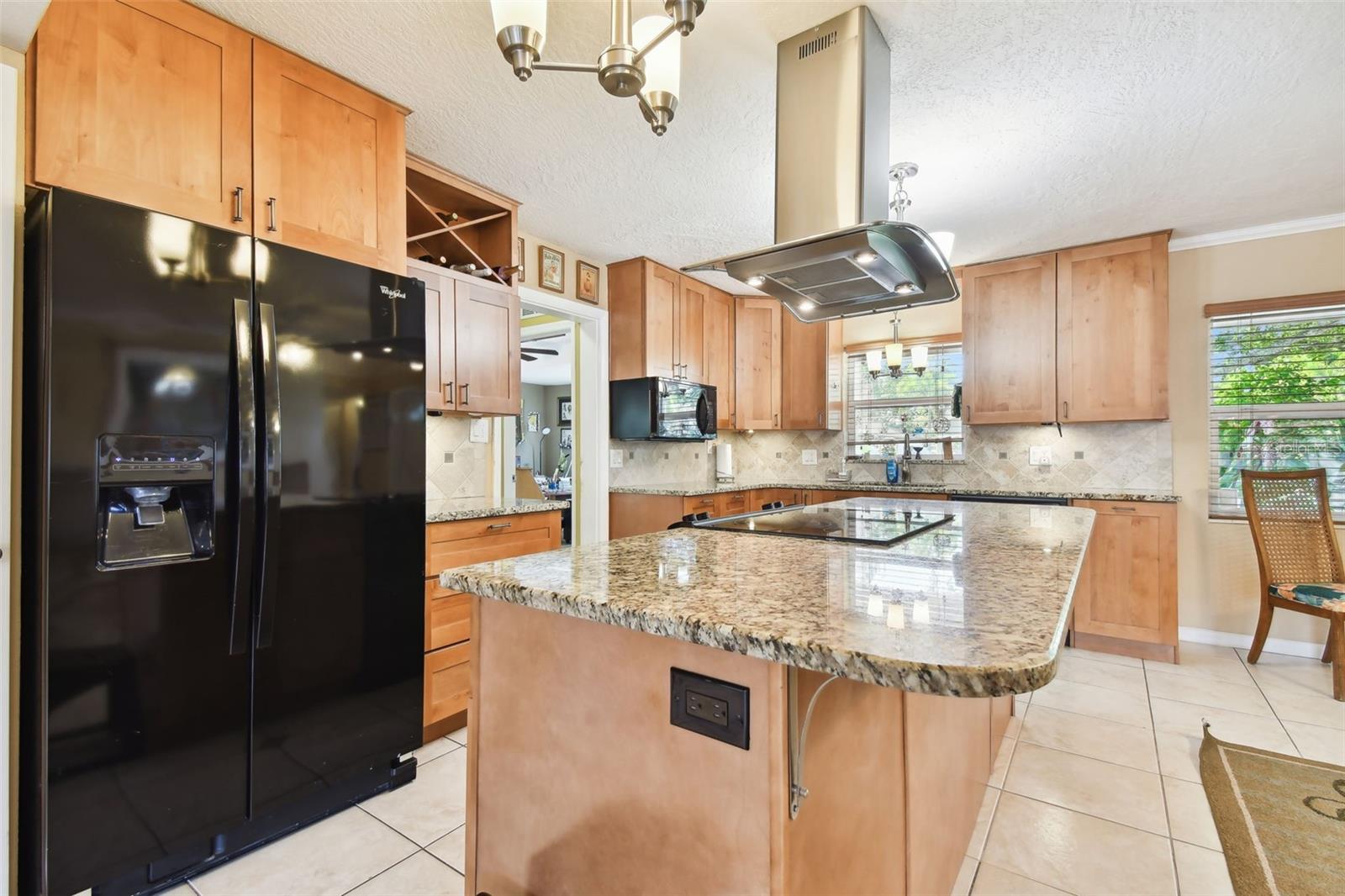 Remodeled kitchen with black appliances: fridge, dishwasher, microwave, electric range/stove. Beautiful Granite tops, wine rack, super exhaust fan, pantry