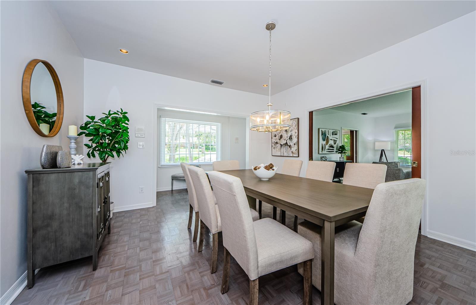 Dinner for eight awaits in this formal dining room with wood parquet floors, and cherry wood french doors to the living room.