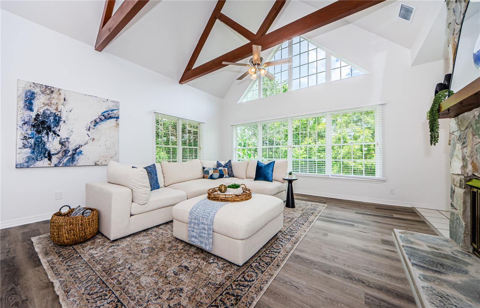 Full shot of this gorgeous main floor family room with two-sided wood burning fireplace.  Vaulted ceilings, lots of windows.