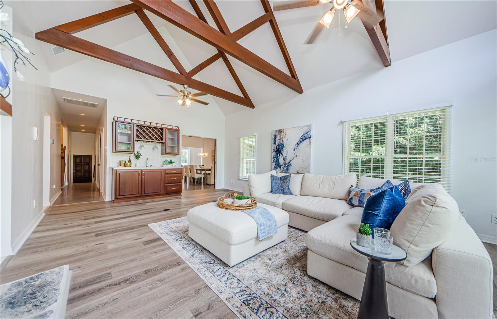 Another shot of this immense family room with rafters, vaulted ceilings, new ceiling fans, fresh paint and luxury vinyl flooring.