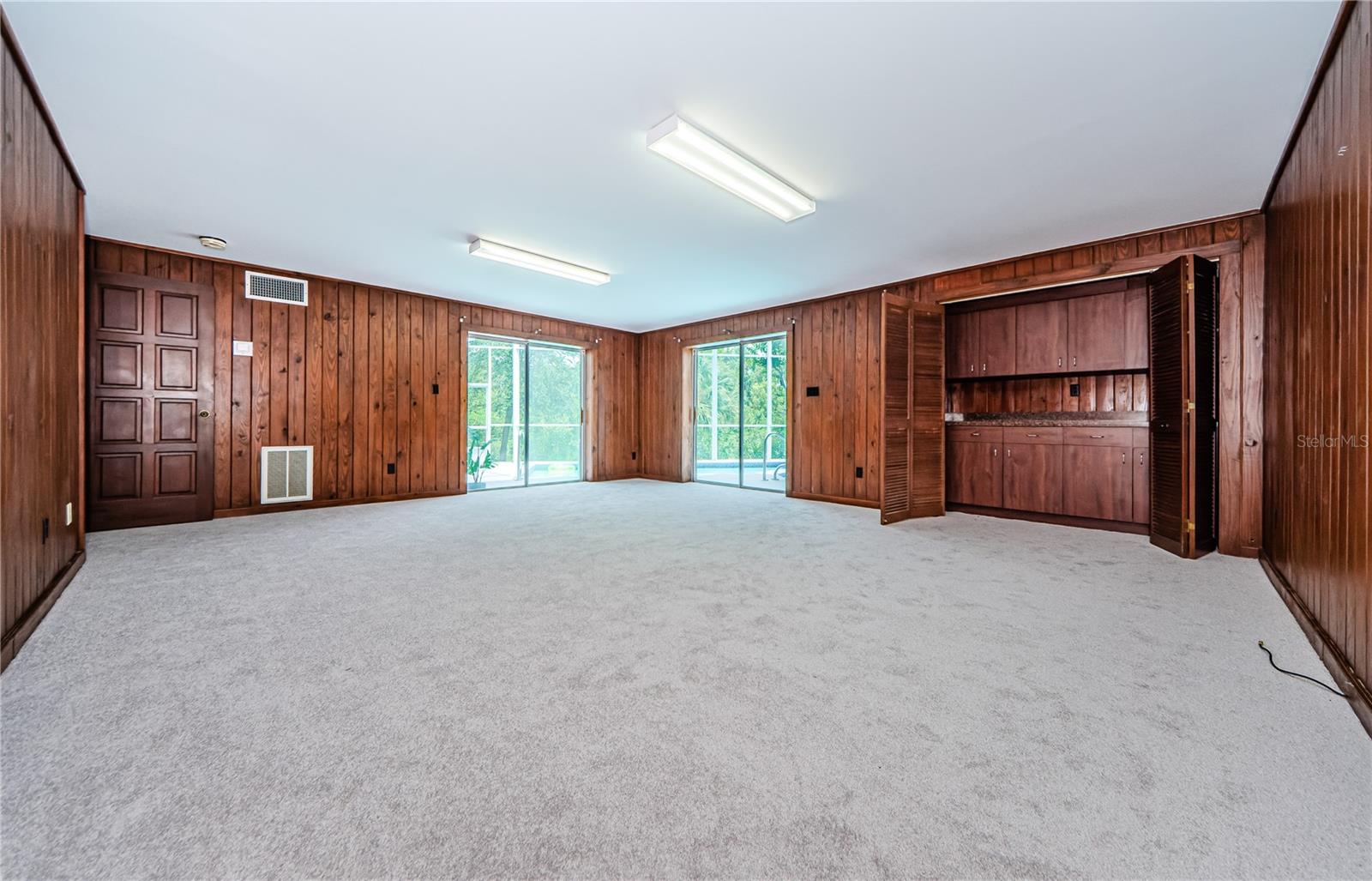 Lower level second family room with two accesses to the patio and pool area. All new carpet and padding.