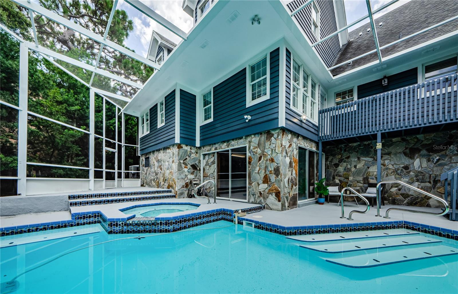 Nice view of the back of the house with the pool and spa.