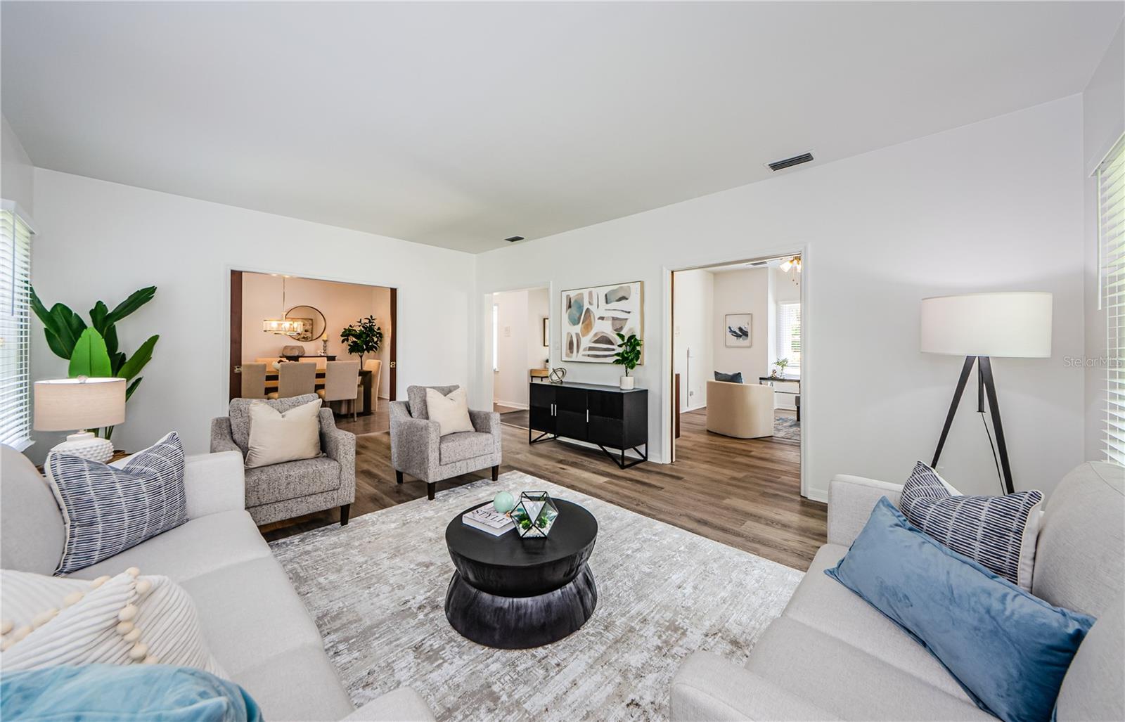 Another picture of the living room looking to the left into the formal dining room and to the right to the library/office both with solid wood french doors.