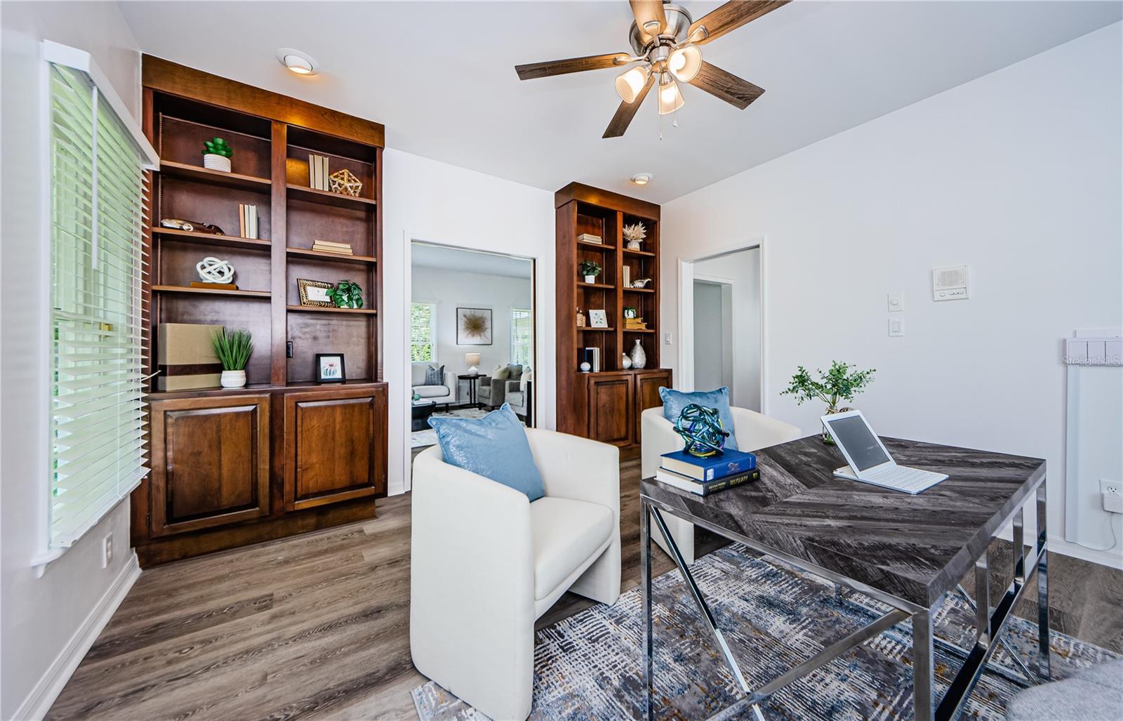 Elegant library/office with shelving made of solid cherry wood and french doors to the living room.  Another large window is positioned behind the desk looking out to the front yard.