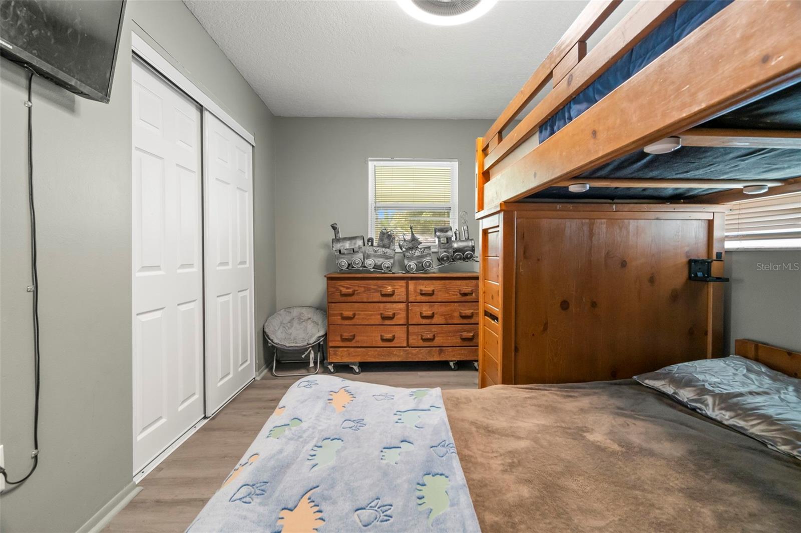 The window in bedroom #2 overlooks the back screened-in porch and yard. Also has a full wall closet