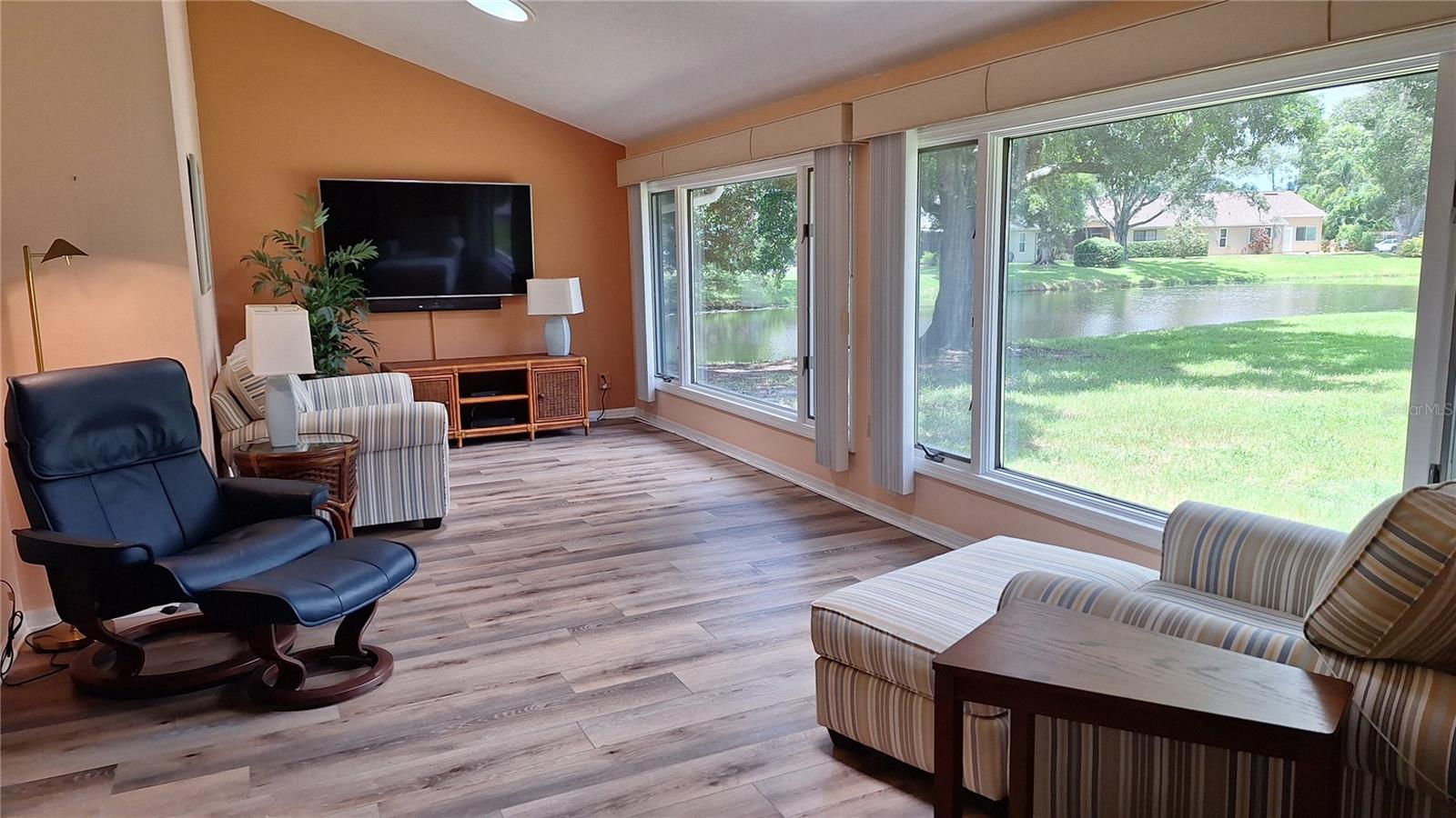 Family room with pond view & vaulted ceiling