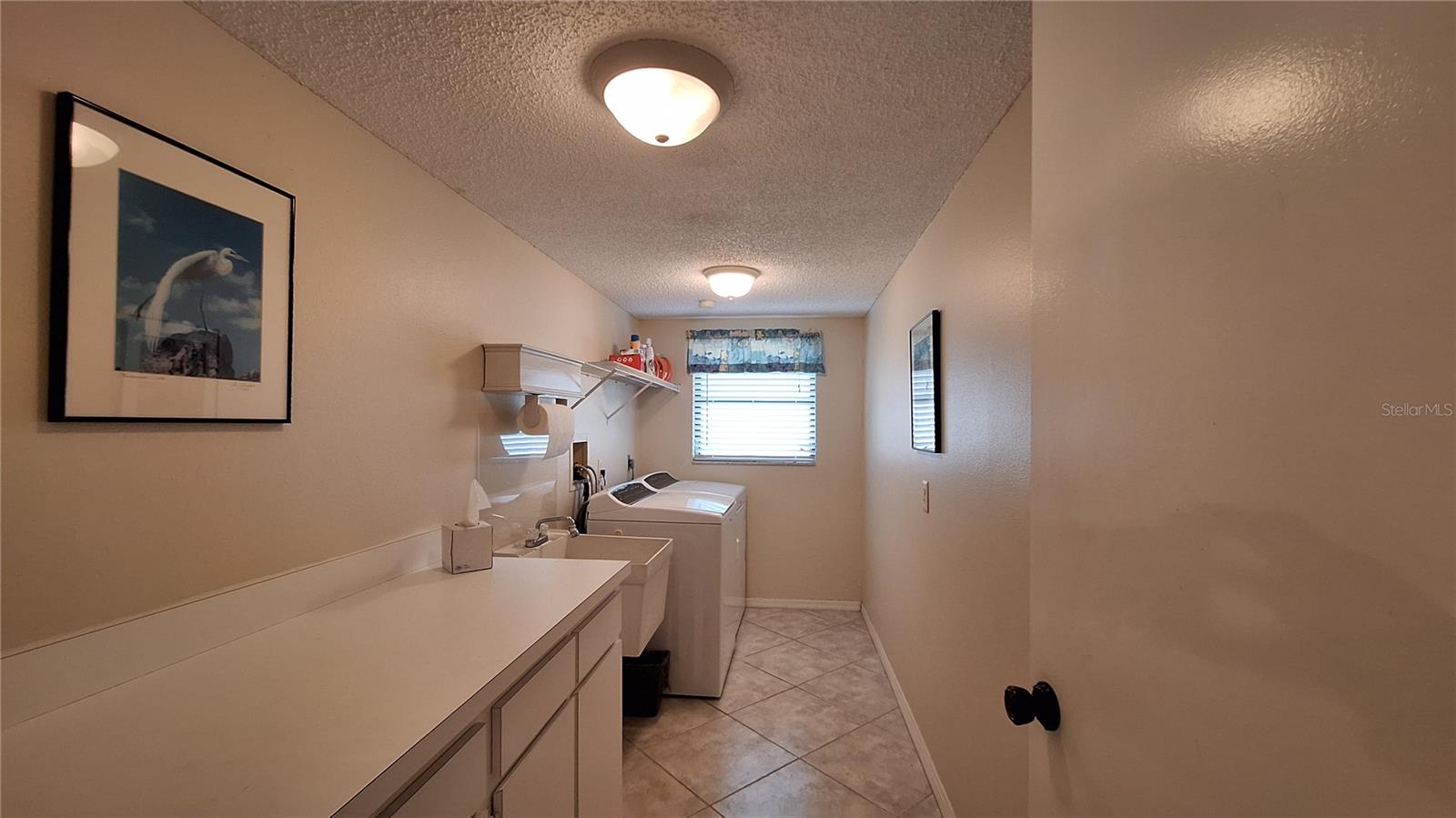 Laundry room with cabinetry, counter space, & utility sink