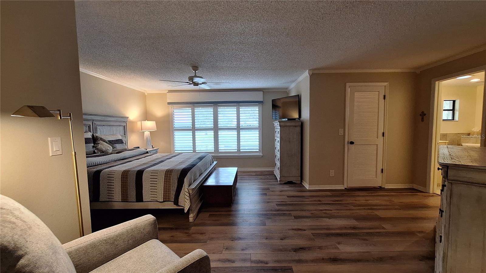 Primary suite featuring pond views walk-in closet, & crown molding