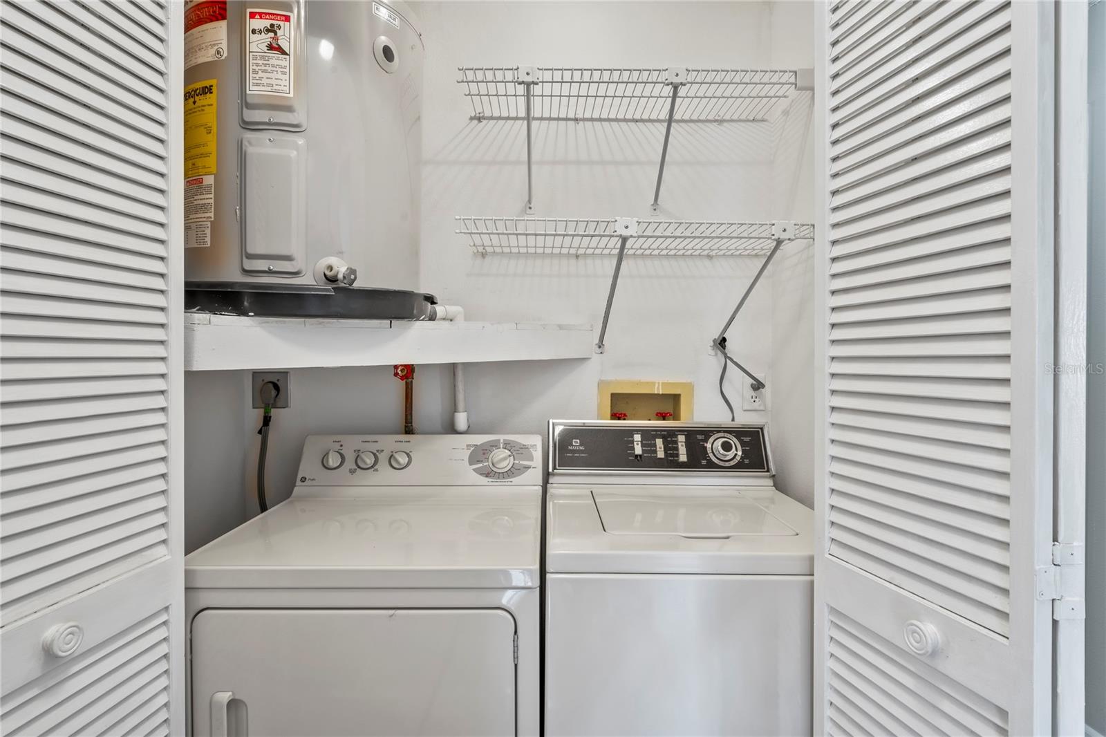 Laundry closet includes the washer and dryer, shelving and houses the water heater.